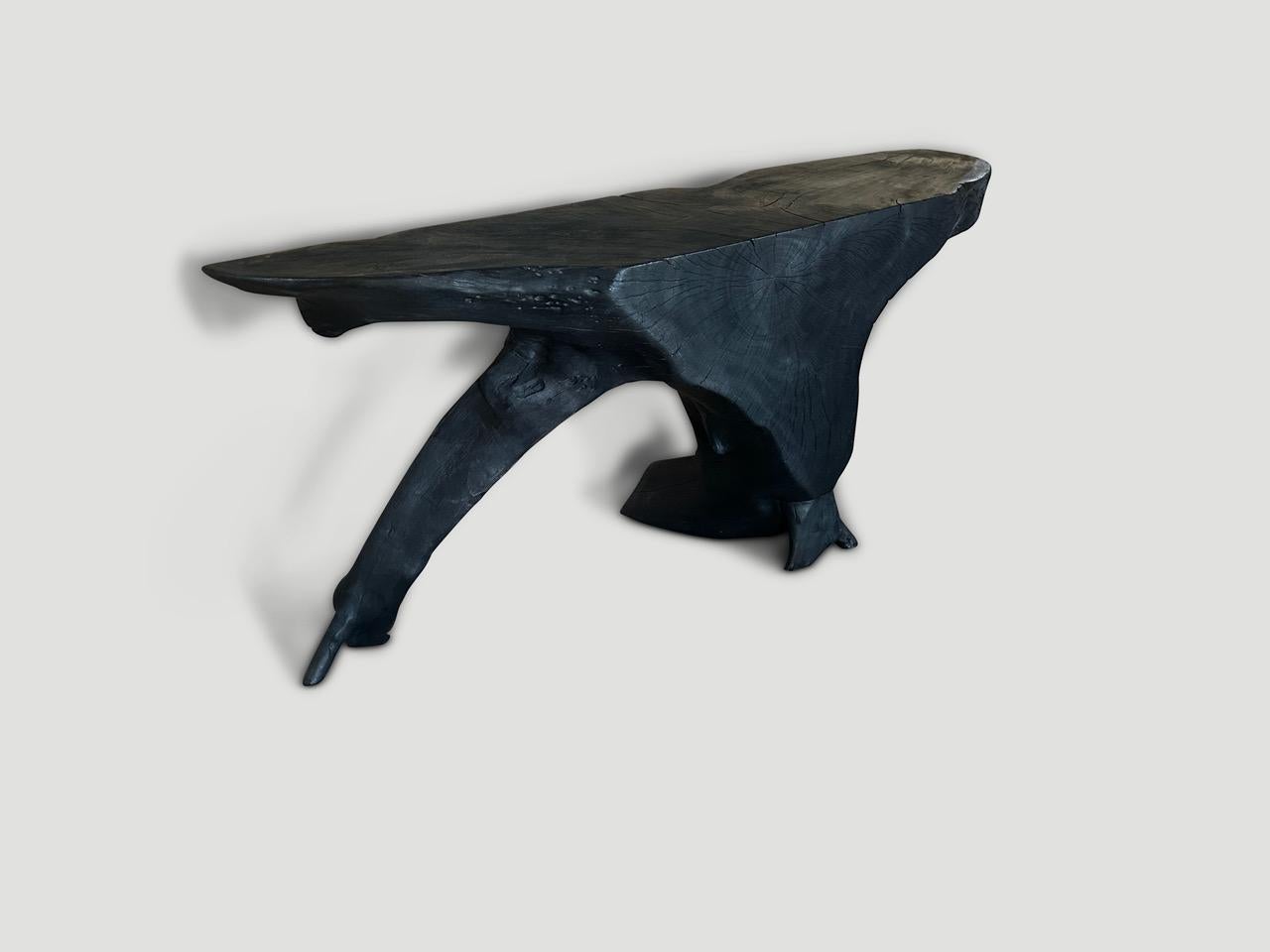 Impressive reclaimed mahogany wood,  hand carved into a one of a kind sculptural console table. Fabulous on both sides. Charred, sanded and sealed revealing the beautiful wood grain. Custom stains and finishes available. Please inquire. 

The Triple