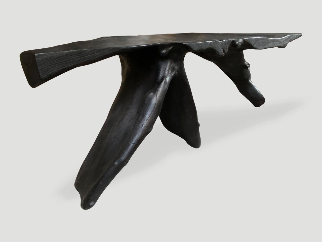 Impressive reclaimed teak root console table hand carved from a single piece of wood and charred black. Stunning on both sides. Functions as a console and a piece of art. 

The Triple Burnt Collection represents a unique line of modern furniture