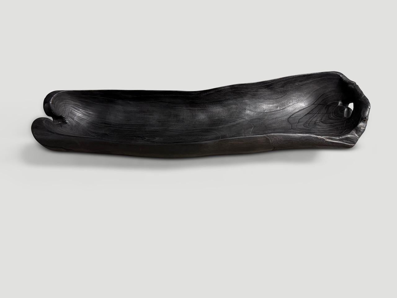 Impressionante imbarcazione lunga e carbonizzata scolpita a mano da un unico pezzo di teak recuperato. Sia utilizzabile che scultoreo. Levigato e sigillato, rivela le bellissime venature del legno. Tutto sta nei dettagli. Dimensioni complete: 37