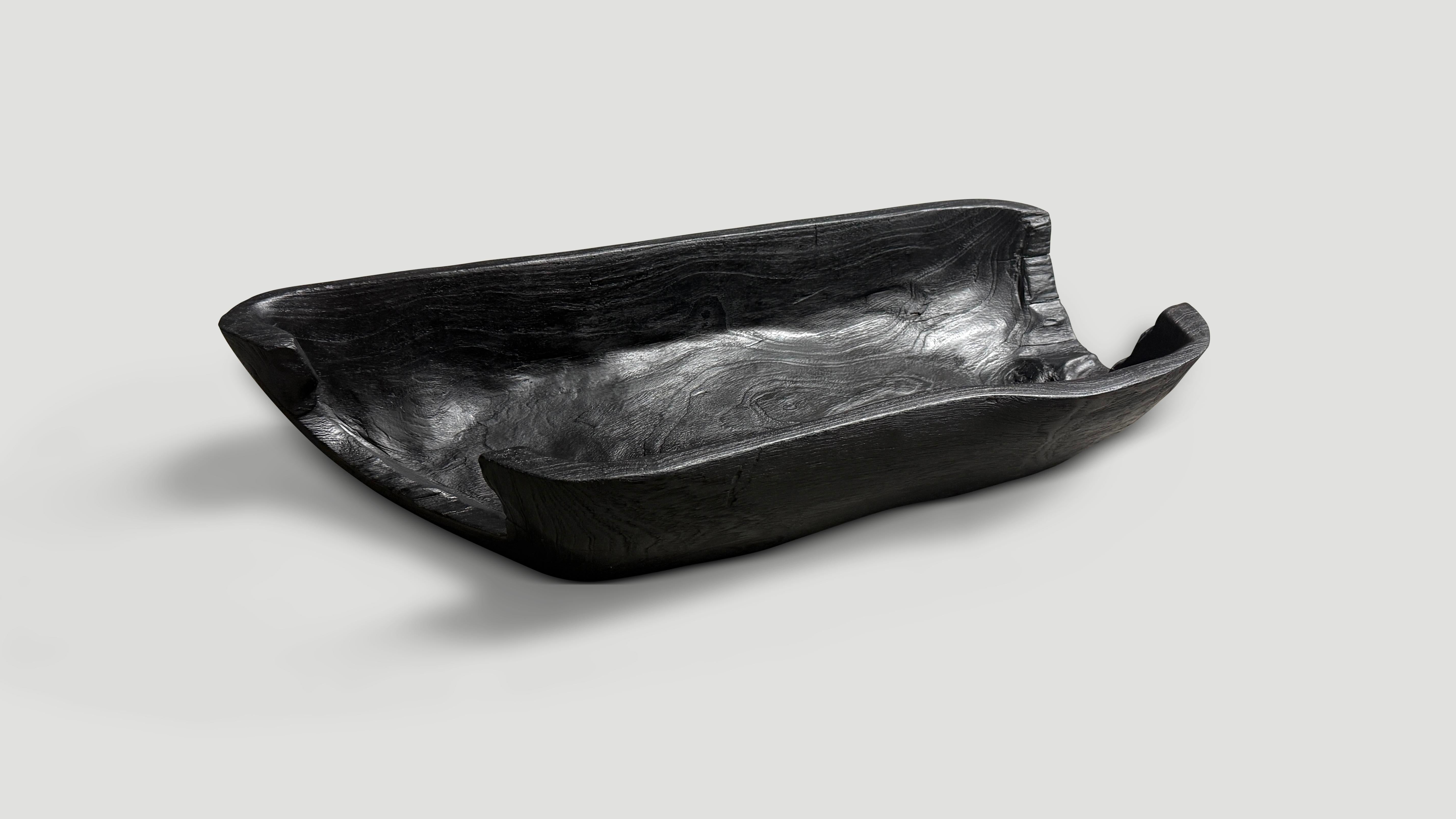 Impressionnant long vaisseau carbonisé sculpté à la main à partir d'une seule pièce de bois de teck récupéré. À la fois utilisable et sculptural. Chargé, poncé et scellé, il révèle les magnifiques veines du bois. Tout est dans les détails. Nous