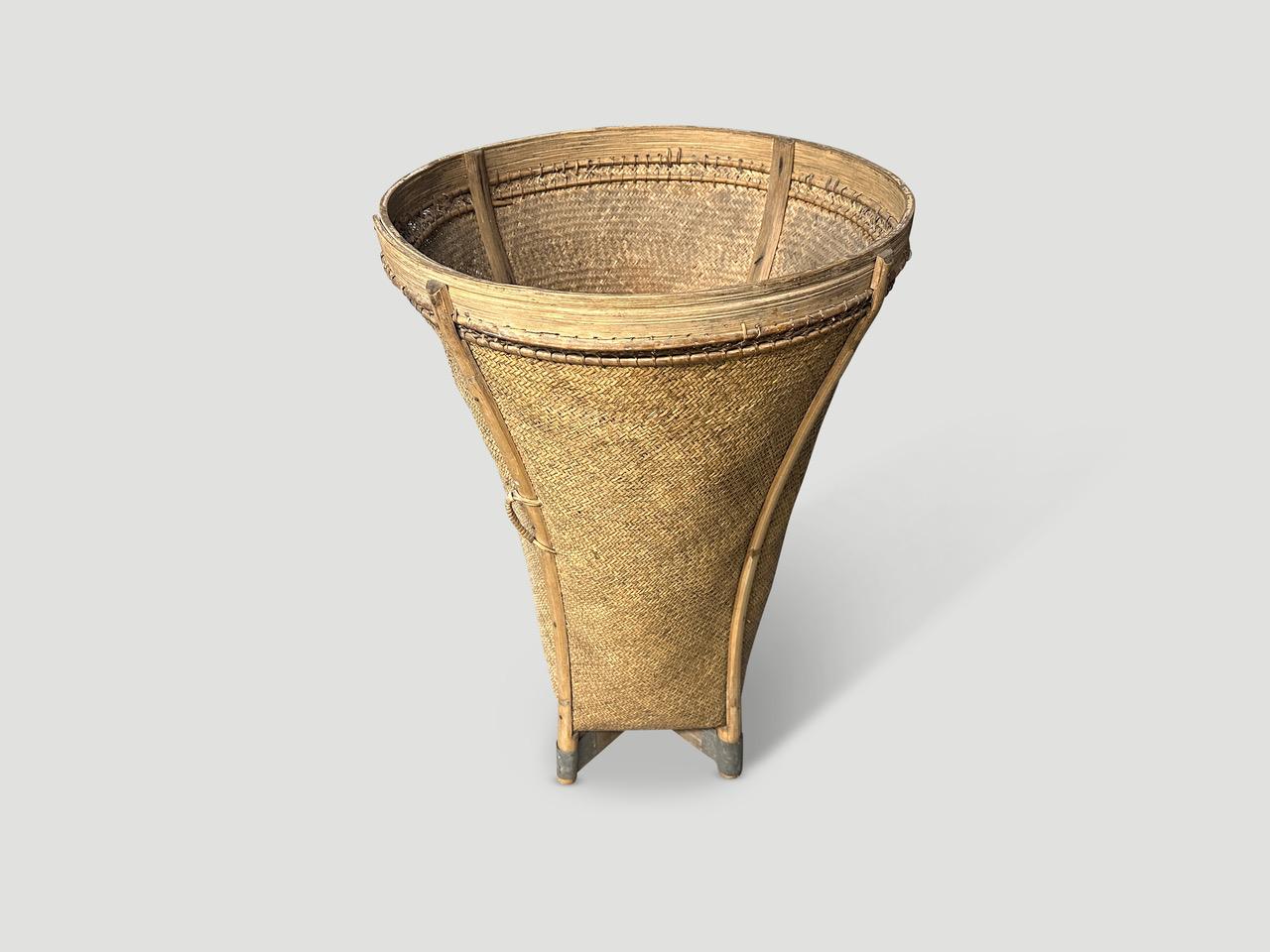 Beautiful simplistic tall hand woven basket. Hand made from tightly woven rattan with bamboo on the sides and wood on the base wrapped in tin. Both sculptural and usable. Full dimensions; 18″ diameter x 27″ high x bottom 12″ diameter. Circa