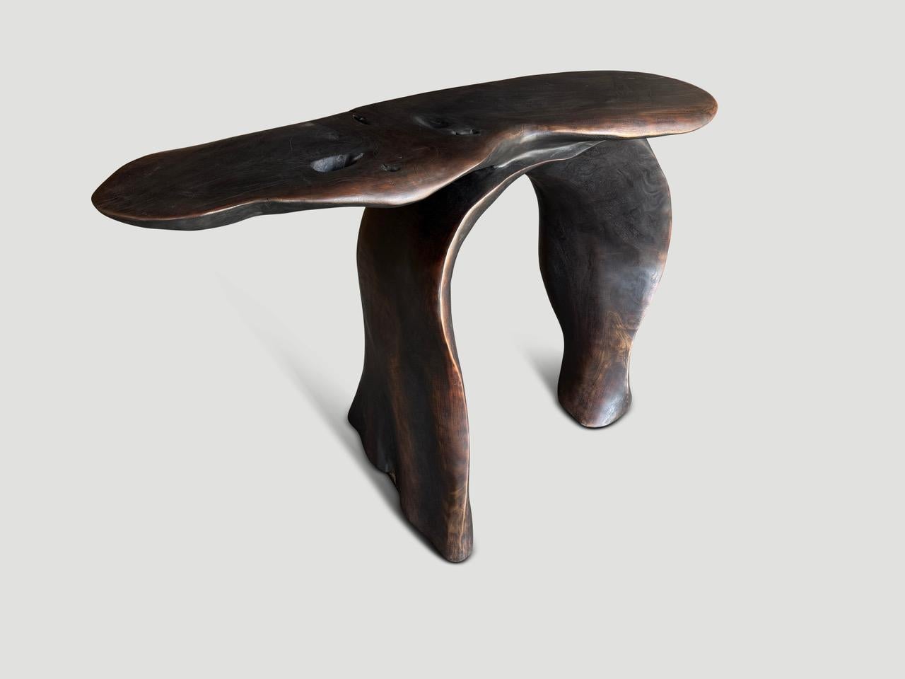 A beautiful reclaimed piece of mahogany wood is hand carved into a sculptural console table or desk. This impressive one of a kind piece is stained a dark brown whilst revealing the beautiful wood grain. It’s all in the details. 

Own an Andrianna