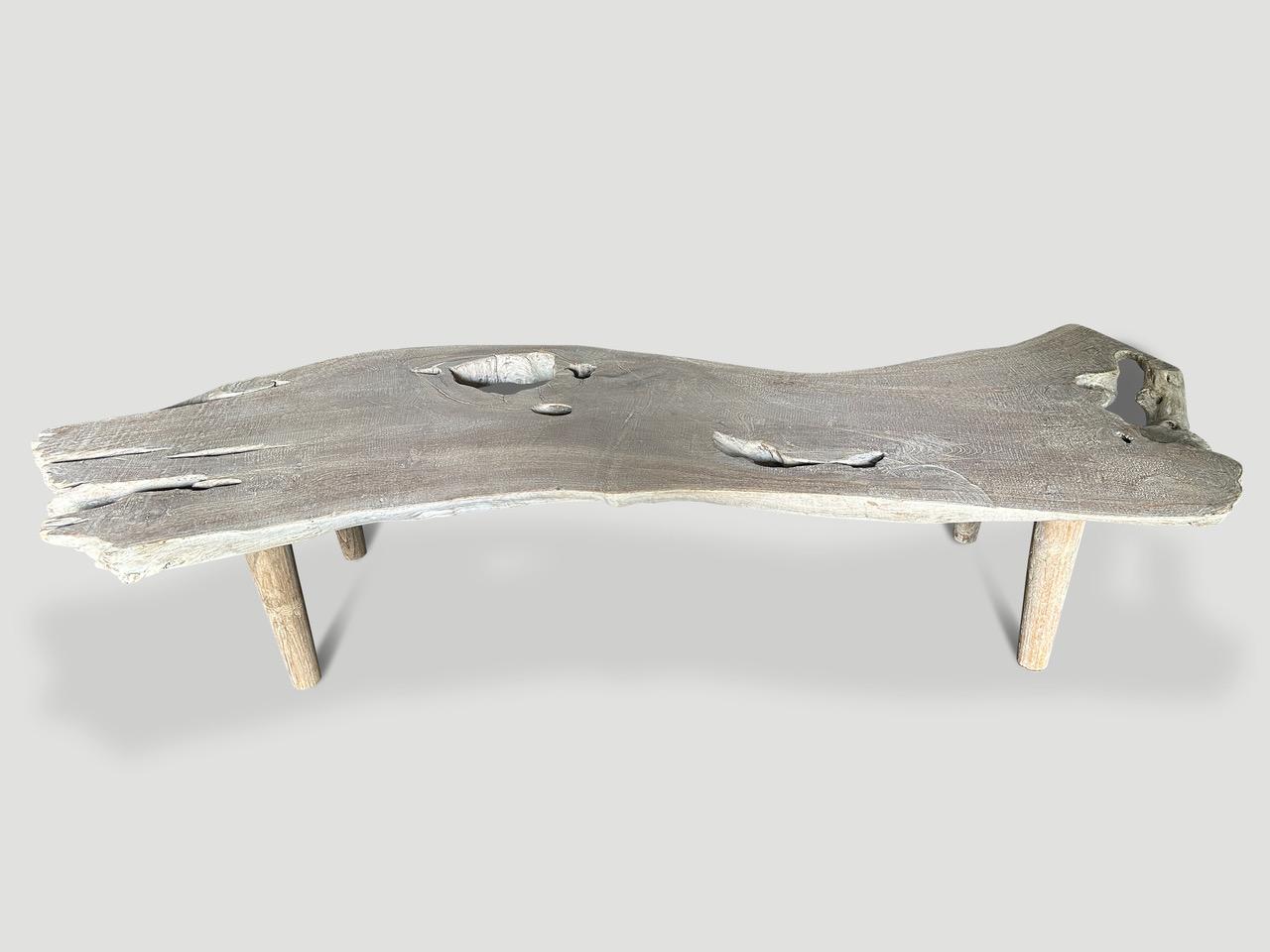 Una singola lastra di teak di notevole spessore viene trasformata in un tavolino o in una panca rispettando la forma organica naturale. Realizzato a mano con un bellissimo legno di teak recuperato, questo splendido pezzo galleggia su gambe in stile
