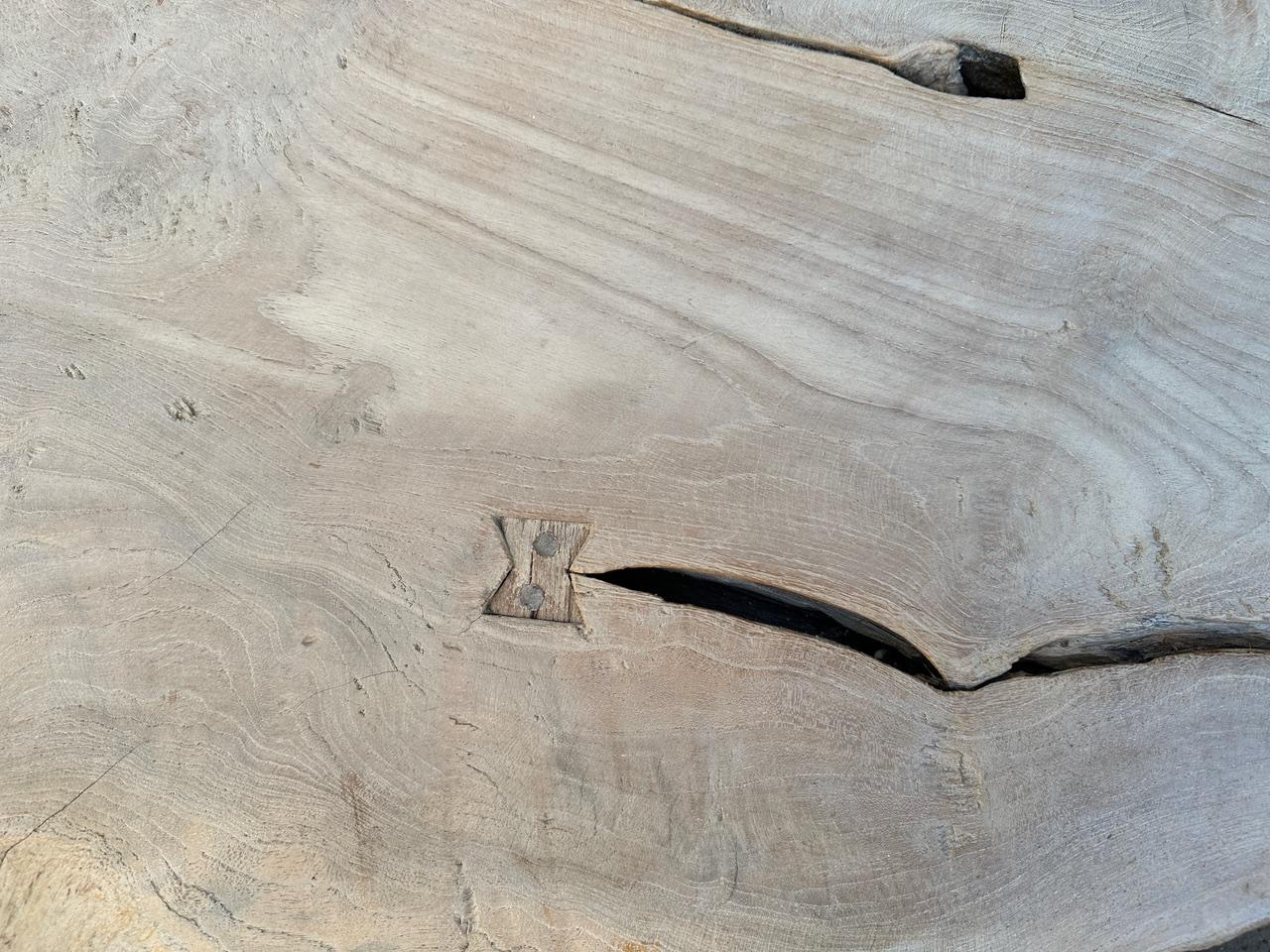 An impressive three inch thick single slab coffee table with butterflies inlaid into the top. Hand made from beautiful reclaimed teak wood, this stunning piece floats on mid-century style legs. Finished with a light white wash revealing the stunning