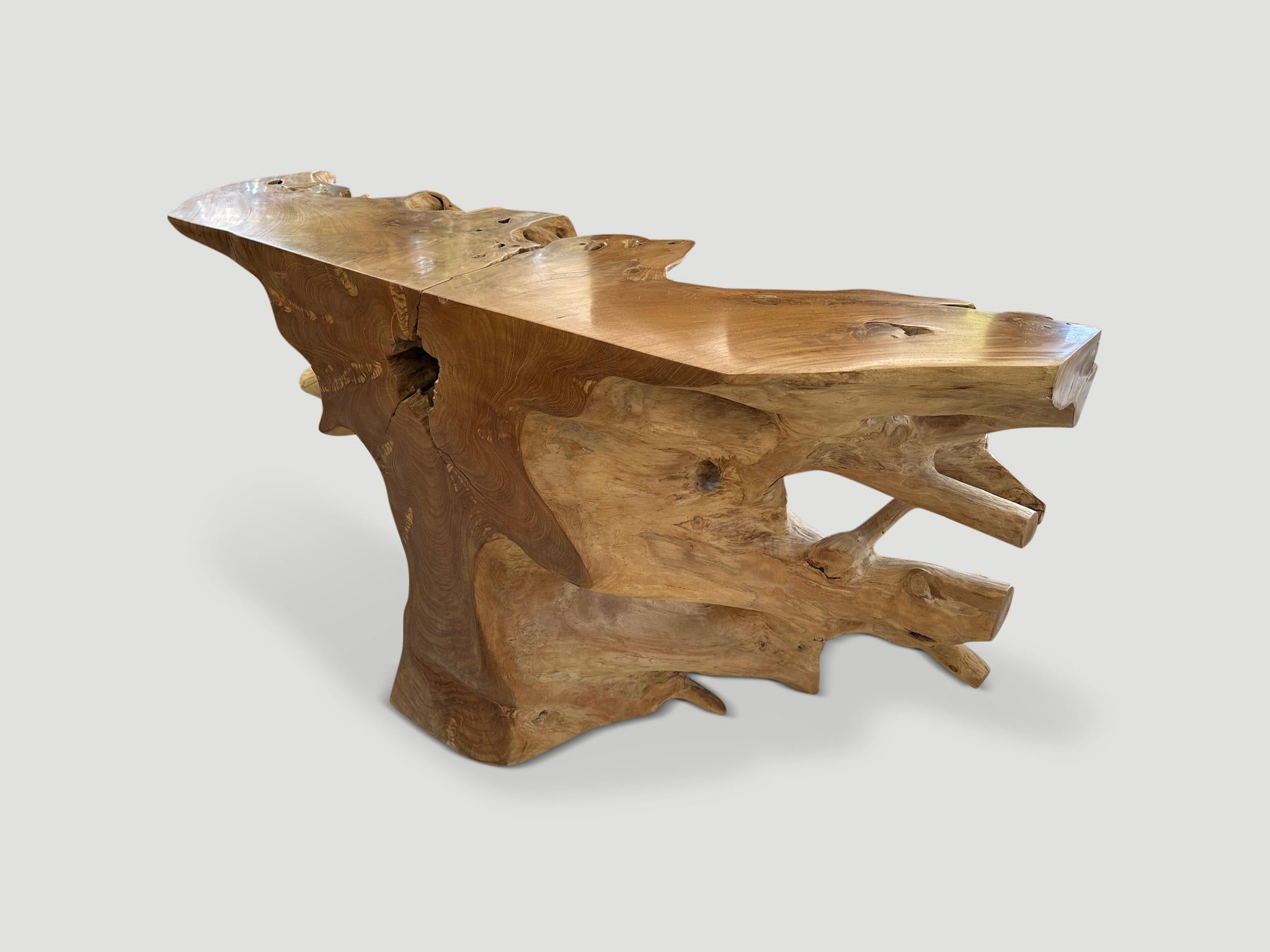 Stunningly beautiful sculptural console table hand carved from a single teak root. The flat surfaces have been polished with a natural oil revealing the beautiful wood grain. We left the more organic sections raw in contrast. It’s all in the