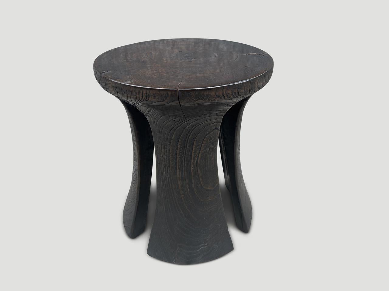 A century old teak wood mortar originally used to grind rice, is repurposed into this minimalist side table or stool. We first turned it upside down and smoothed out the entire piece then added sleek cut outs on the sides with a small butterfly