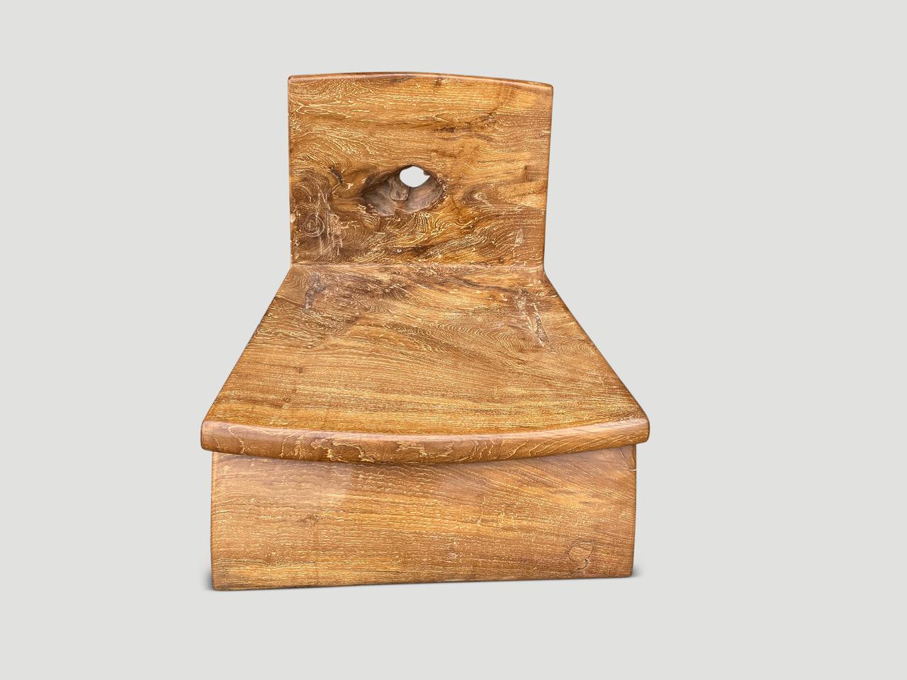 Beeindruckender niedriger Stuhl, handgefertigt aus jahrhundertealtem Teakholz mit schönem Charakter. Das vordere Bein, der Sitz und die Rückenlehne sind aus einem einzigen Block alten Teakholzes handgeschnitzt. Wir haben ein einzelnes Stück Holz für