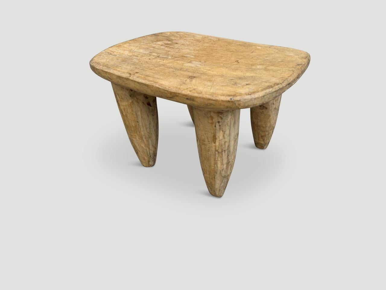 Beautiful antique side table or stool hand carved by the Senufo tribes from a single block of mahogany wood native to the west coast of Africa. The wood is tough, dense and very durable. Shown with cone style legs. The light tone wood on this one is