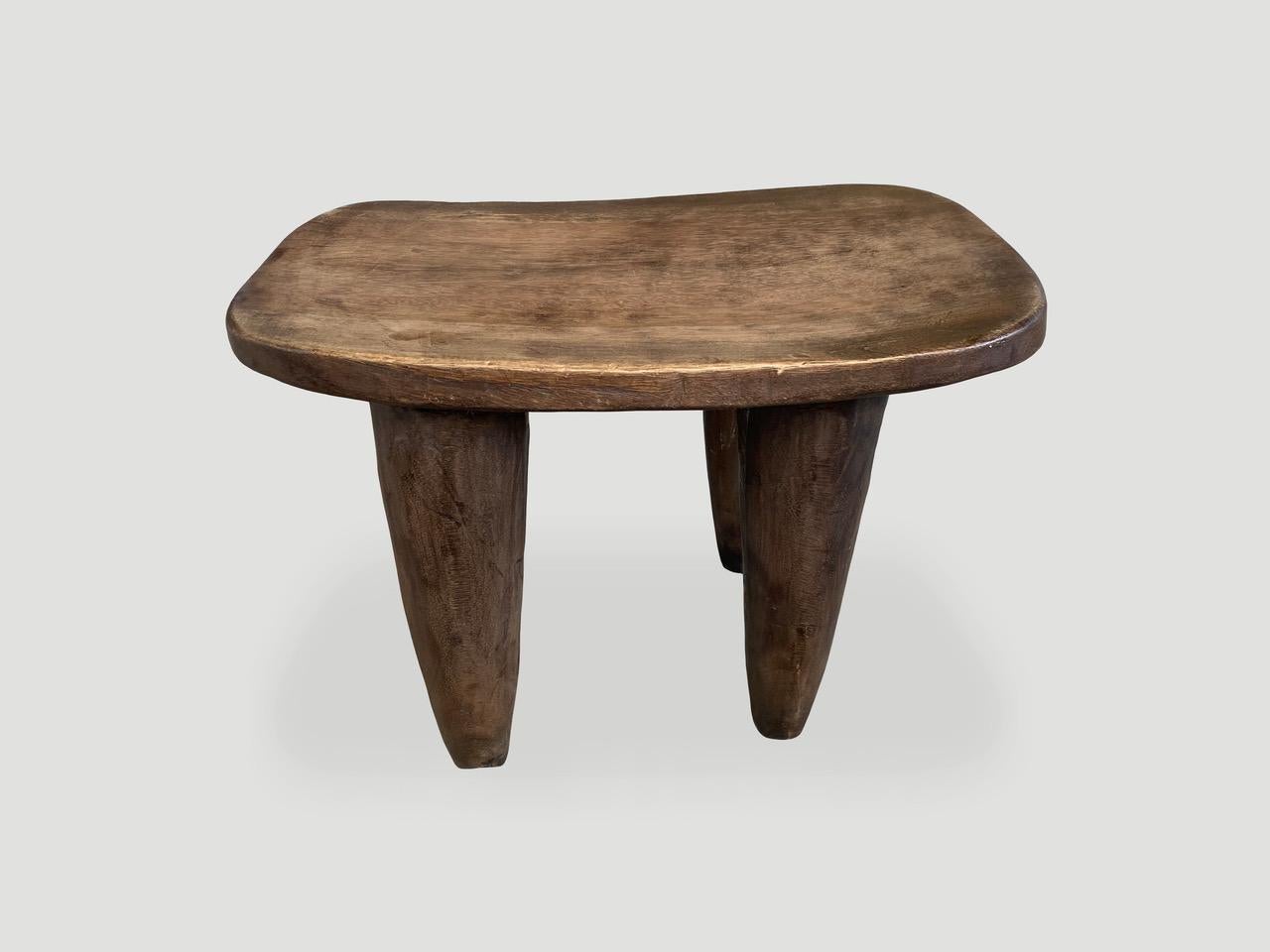 Beautiful antique side table or small bench, hand carved from a single block of wood with beautiful patina. Both sculptural and usable. Shown with cone style legs. We only source the best. 

This side table or stool was sourced in the spirit of