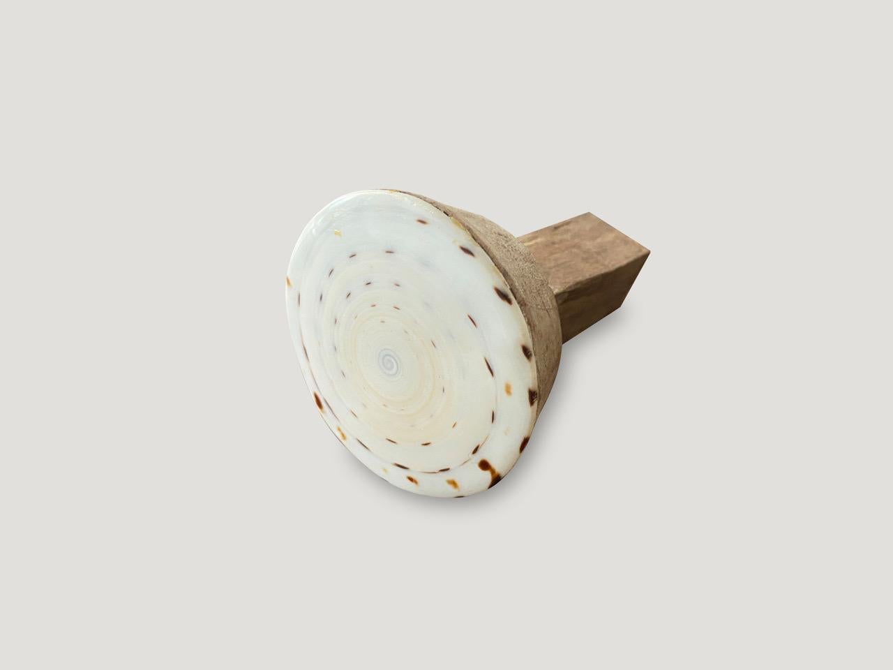 We have taken the flat bottom section of a cone shaped shell and added teak wood for beautiful one of a kind door knobs. We have a collection. Great installed in bathrooms, kitchens or on cabinets as shown in the last image. The price reflects