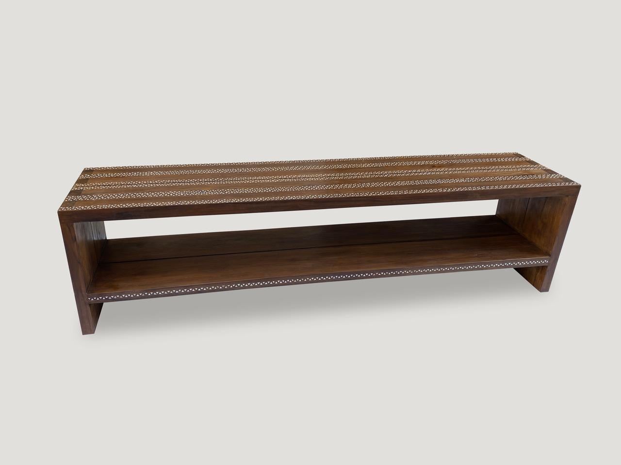 Impressive reclaimed teak wood console table with added shell inlay. Shown with a shelf 8” off the floor. The hand cut shell is inlaid into the teak wood on this beautiful console table. Custom styles available. Please inquire.

Own an Andrianna