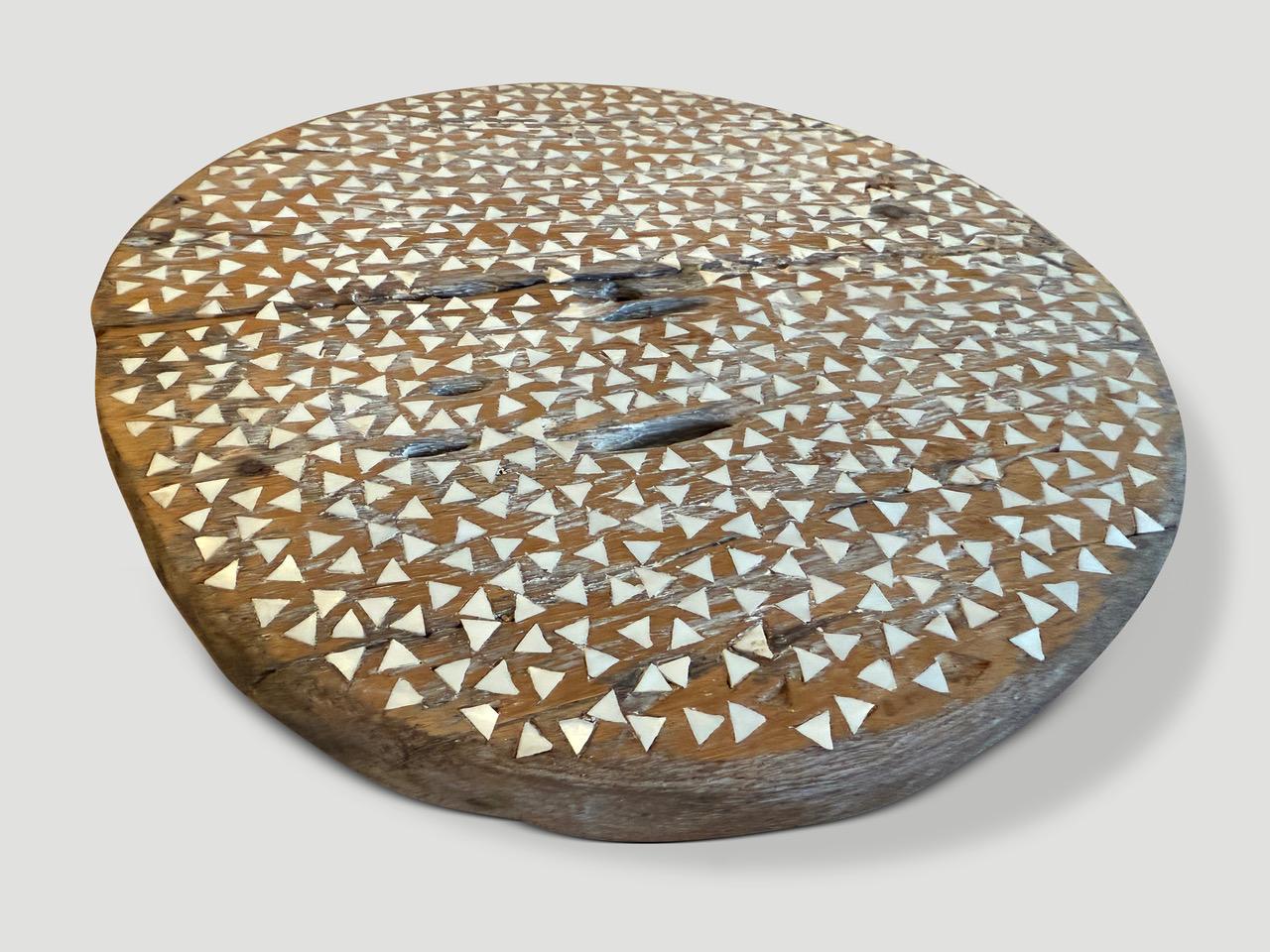 Pezzi di madreperla tagliati a mano sono accuratamente intarsiati in questa ruota antica in legno di teak. Ottimo come installazione artistica.

Questa antica ruota intarsiata di conchiglie è stata realizzata a mano nello spirito del Wabi-Sabi, una