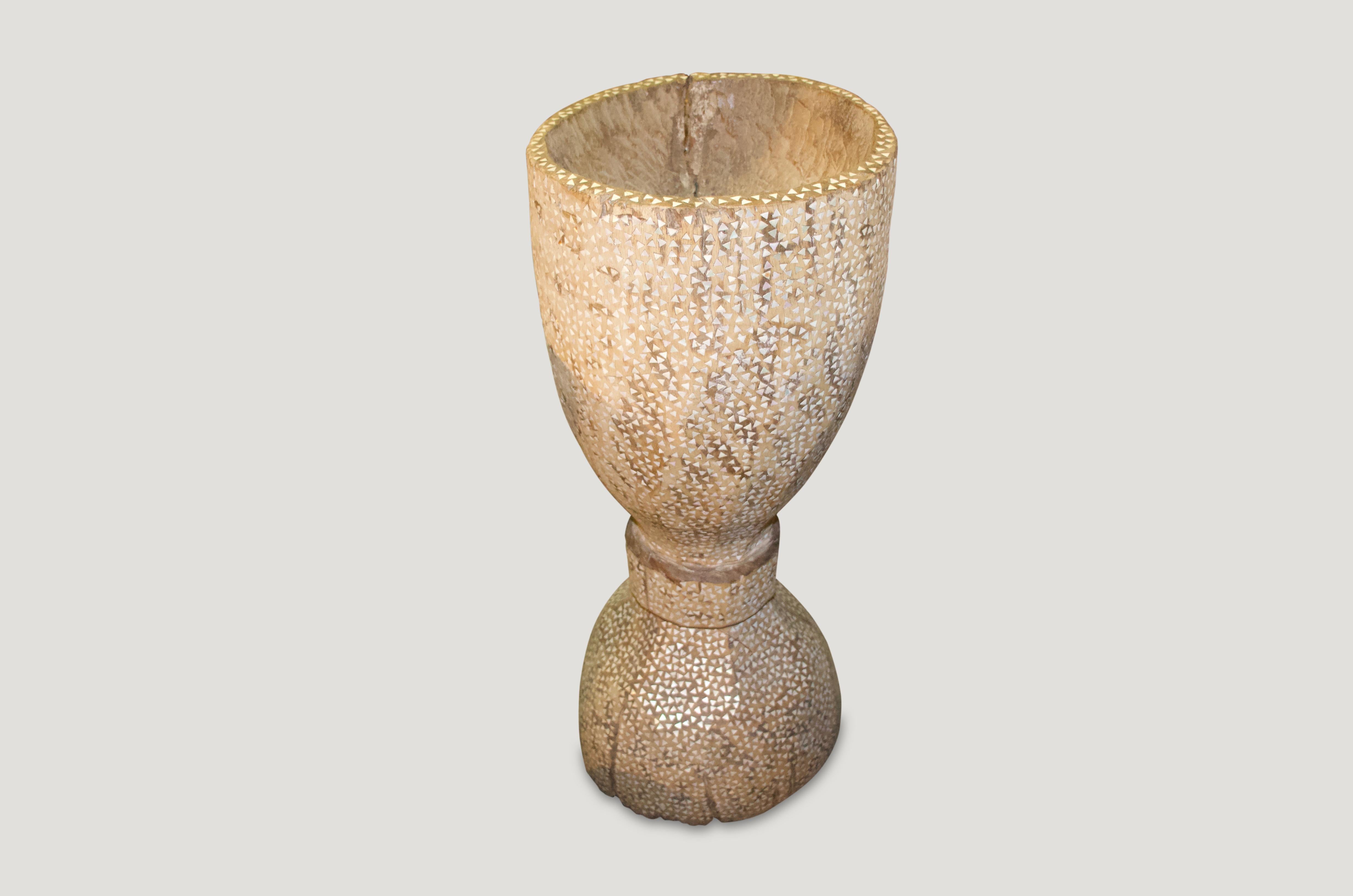 Antique rice pounder hand carved from a single teak root. We added the shell inlay. Beautiful as a sculpture, holding towels or great as a champagne holder for parties. Also as a table base with a glass top.

This rice pounder was sourced in the