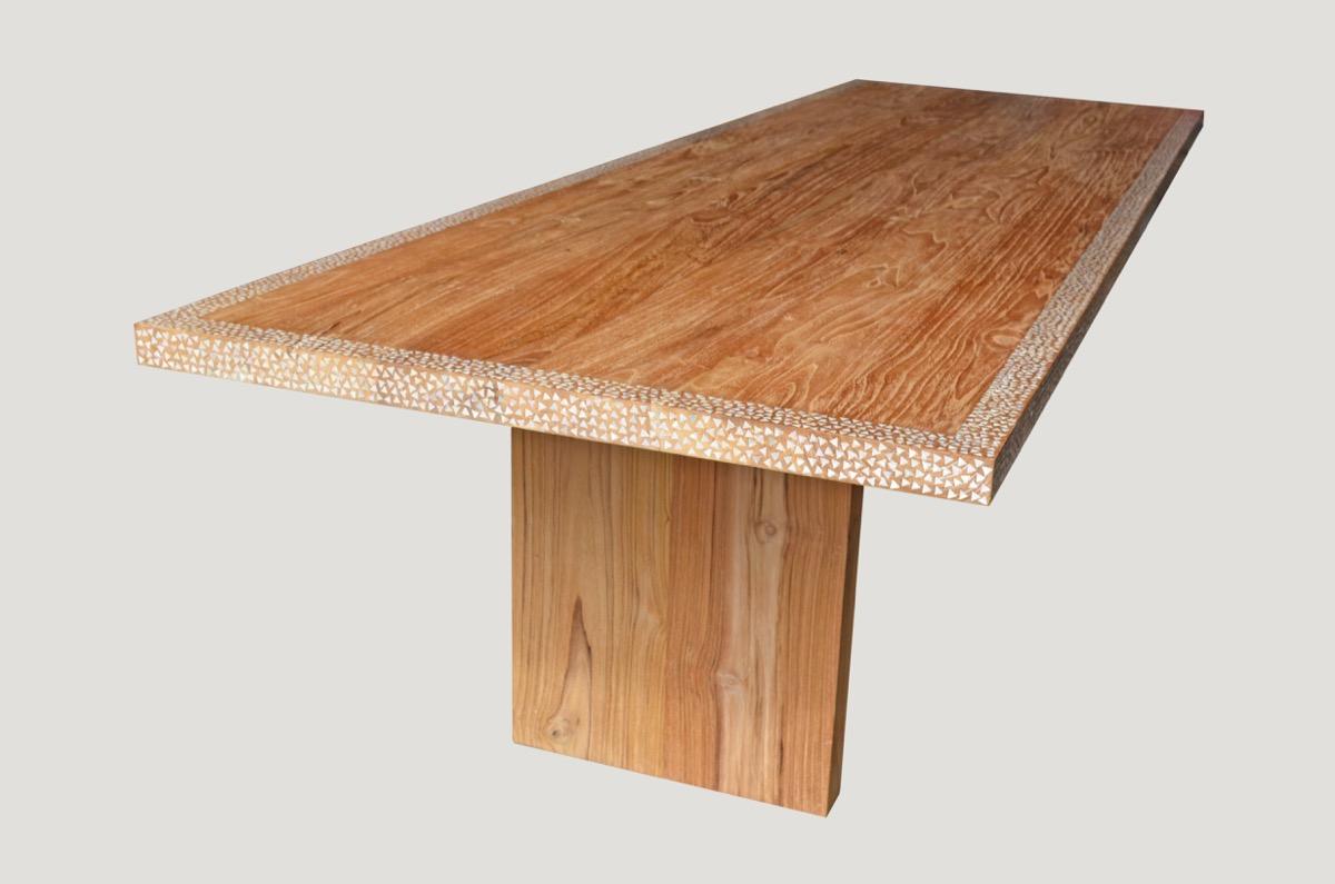 Reclaimed teak wood with added shell inlay on the top and edge, floating on modern L style base. Perfect for inside or outside dining. Hand cut shell is inlaid into the teak wood on this minimalist table. Custom sizes available.

Own an Andrianna