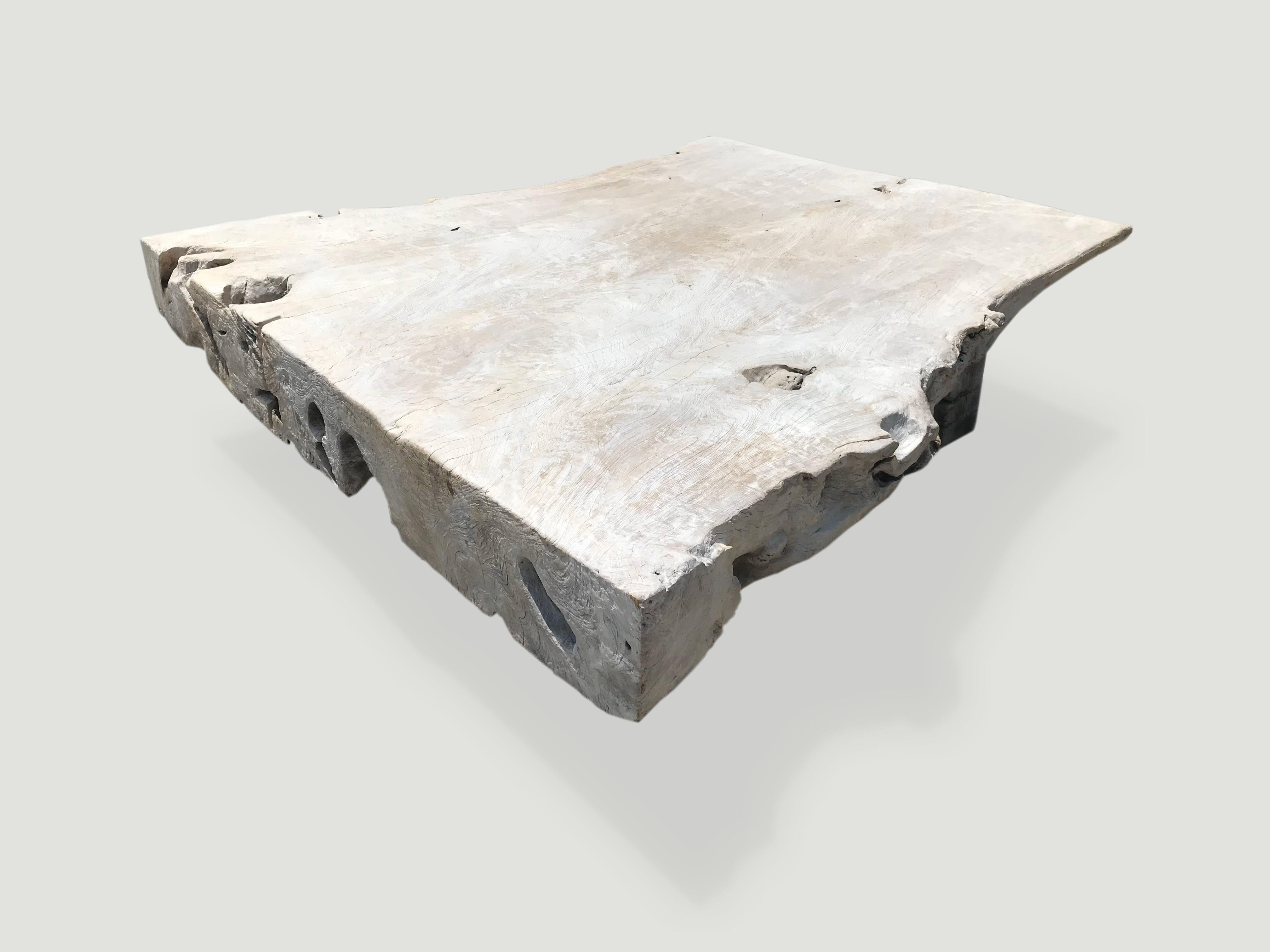 Impressive reclaimed teak wood coffee table celebrating the natural cracks and crevices that time and loving use have left behind. Fabulous live edge with a thickness that expands from three inches to nine inches.  We have added a light ceruse