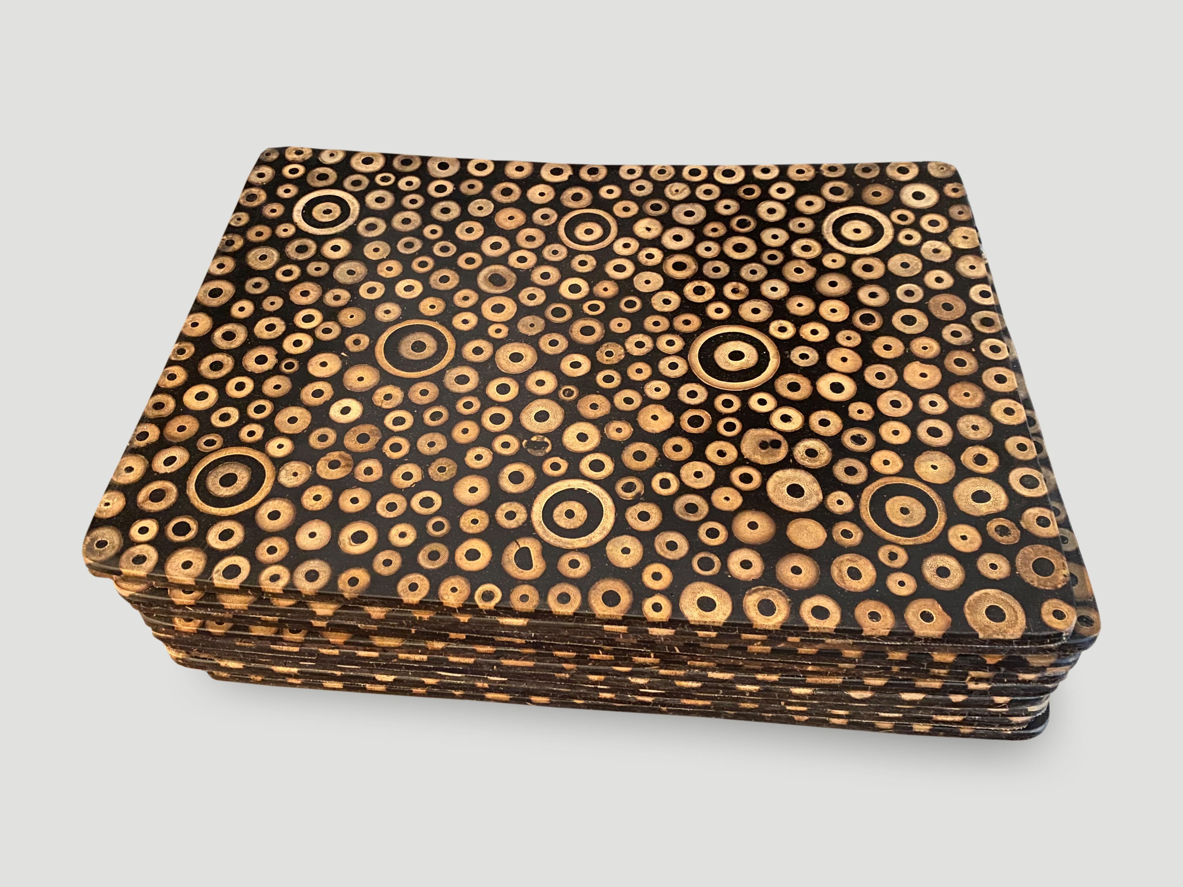 Espresso resin with sliced bamboo inlaid placemats.

Unique fusion of modern and natural elements. Each natural bamboo slice is carefully inlayed into the resin, which is stained black to create a sleek, modern aesthetic. This design is featured