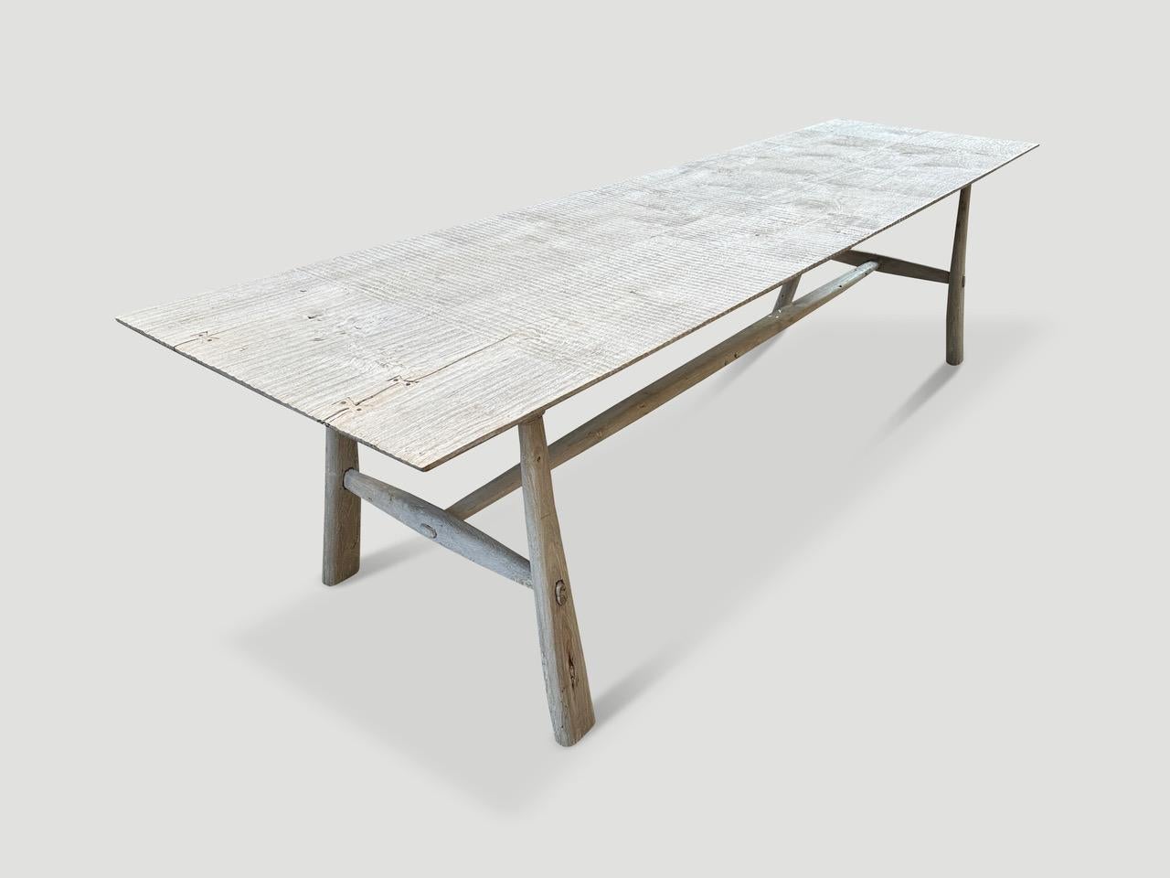 An impressive three inch thick single slab coffee table. Hand made from beautiful reclaimed teak wood, this stunning piece floats on mid-century style conical legs. Organic with a twist. Finished with a light white wash revealing the beautiful wood