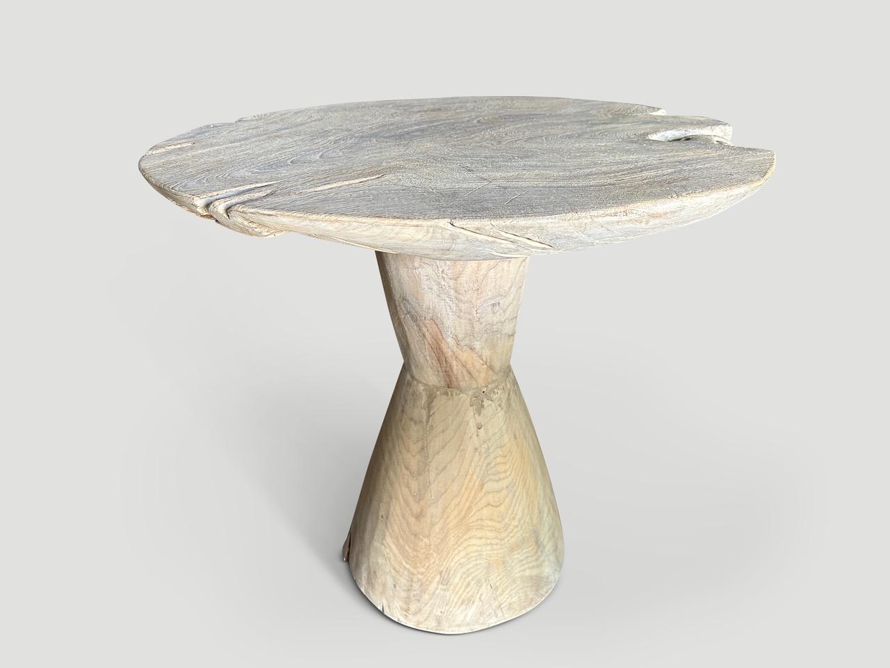 A single aged organic slab of reclaimed teak wood taken from my finest collection, is turned into a one of a kind table. The top is originally four inches thick which we have carved by hand to a dramatic bevel with soft smooth rounded sides. Shown