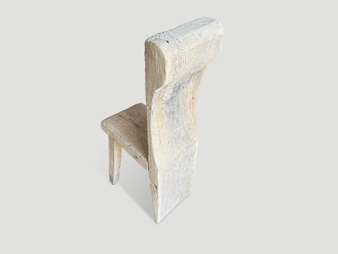 Sedia scultorea unica del secolo scorso. Lo schienale è un unico pezzo di spesso legno di teak antico con un bellissimo cartiglio intagliato a mano nella parte superiore. Abbiamo aggiunto una farfalla intarsiata nella seduta attraverso la fessura