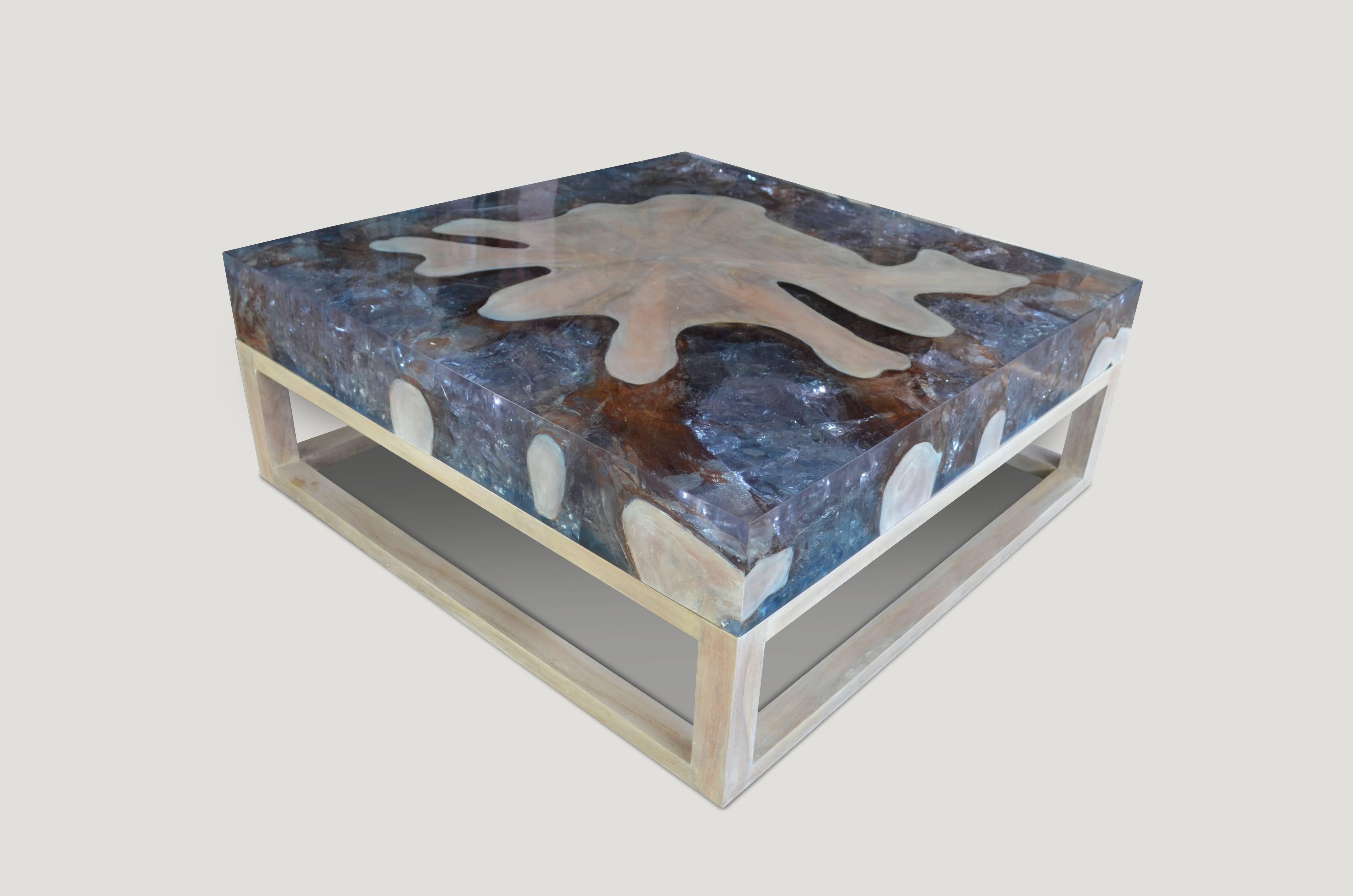 This St. Barts coffee table is made from reclaimed teak infused with aqua resin, which resembles a unique quartz crystal with many different facets, as shown here with gold, warm tones created naturally within the wood. Straight modern lines with a