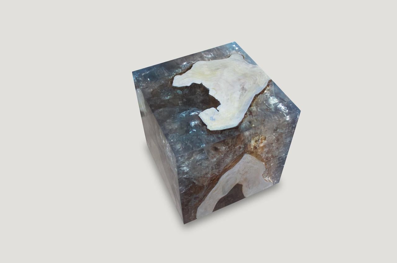 The St. Barts side table is a unique variation of the teak and cracked resin cube. Ice blue or aqua resin is first cracked and added into the natural grooves of the bleached teak wood, sanded and finished with a high polish. Hand made from reclaimed