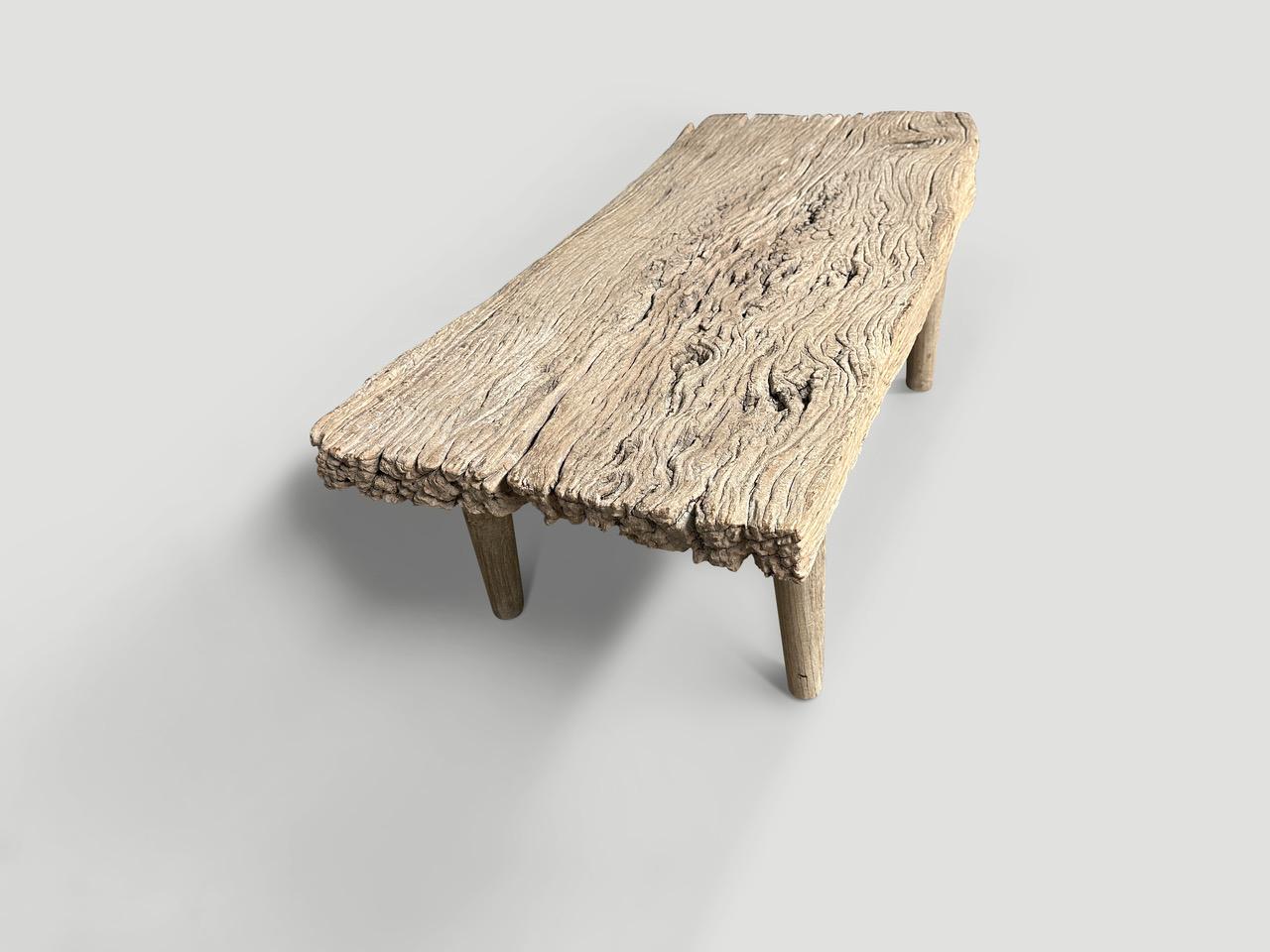Une seule plaque de bois de teck de trois pouces d'épaisseur est transformée à la main en cette magnifique table basse ou banc au caractère naturel unique. Nous avons ajouté des pieds minimalistes en teck lisse à ce bois ancien unique. Tout est dans