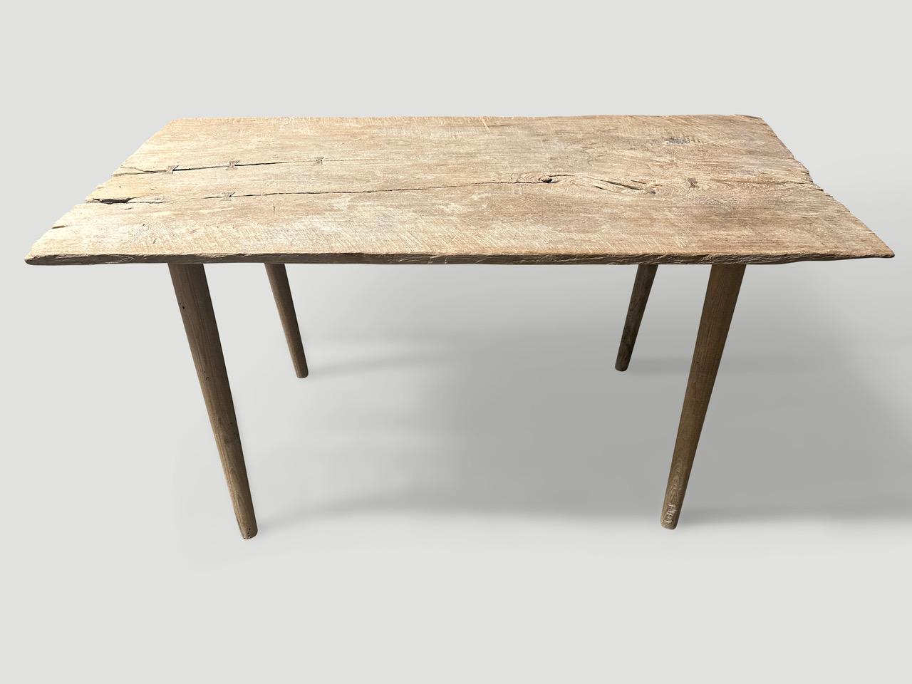 A single antique wood panel with lovely character. We added smooth teak minimalist legs to form this beautiful console, desk or small dining table. Butterflies are inlaid into the table top. First bleached and finished with a light white wash