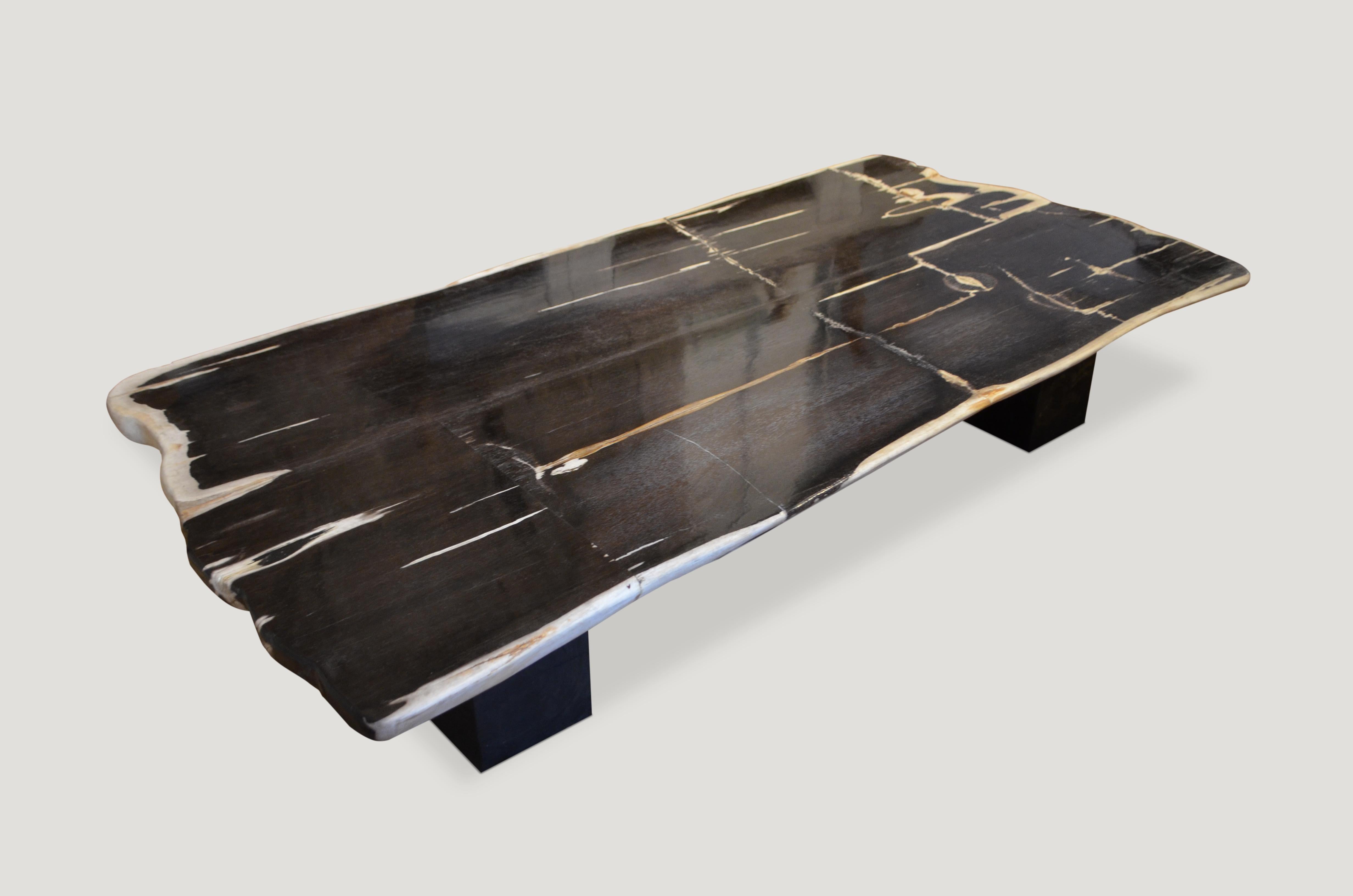 High quality super smooth petrified wood coffee table, dining table or counter top. Stunning black and white, charcoal grey and natural tones make this an impressive piece for any space. This two inch thick slab is shown floating on two espresso
