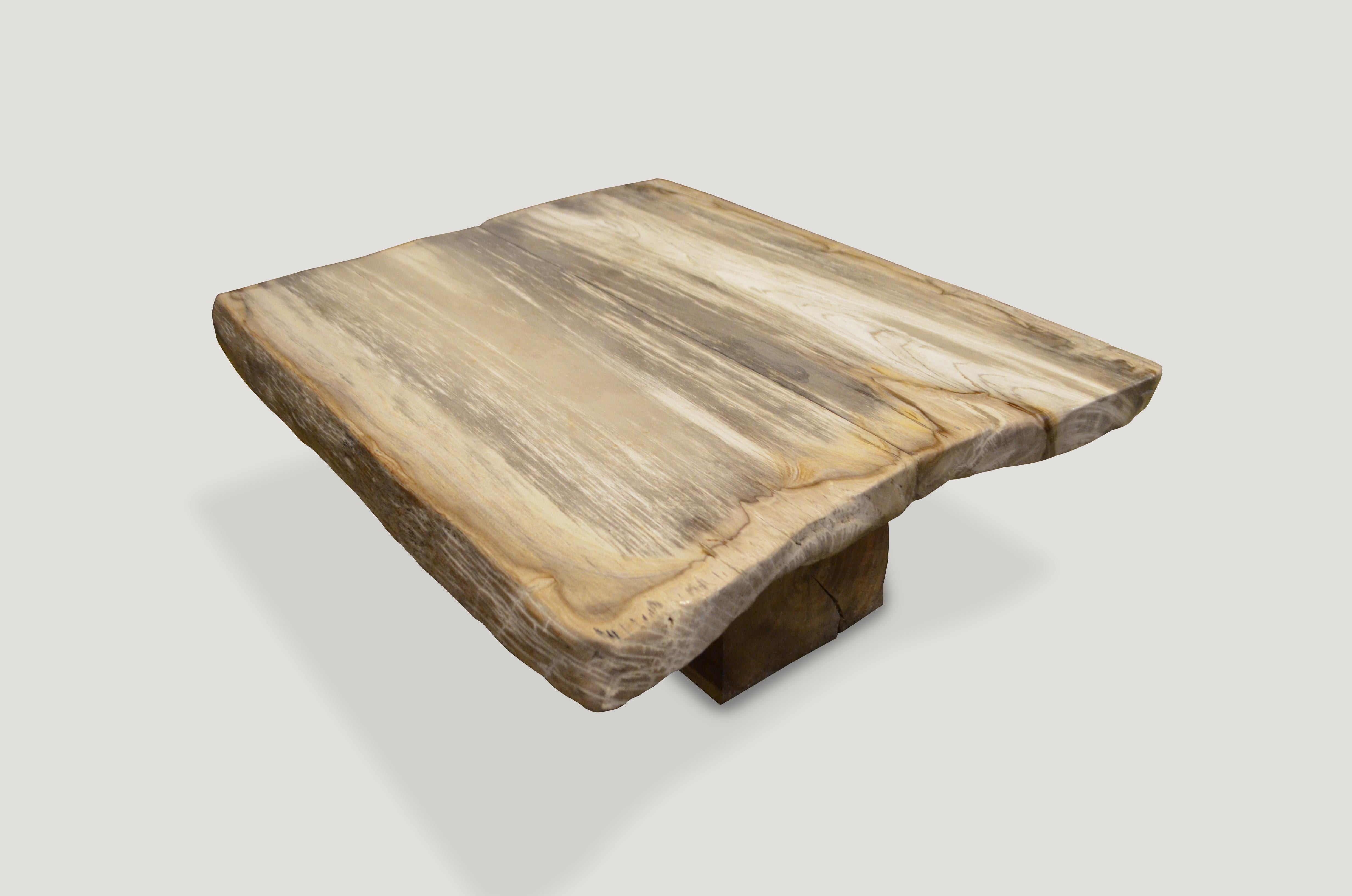 High quality super smooth petrified wood coffee table or counter top. Stunning cream and beige tones on this impressive three inch slab floating on a single natural teak base. The height can be modified depending on the desired use. 

We source