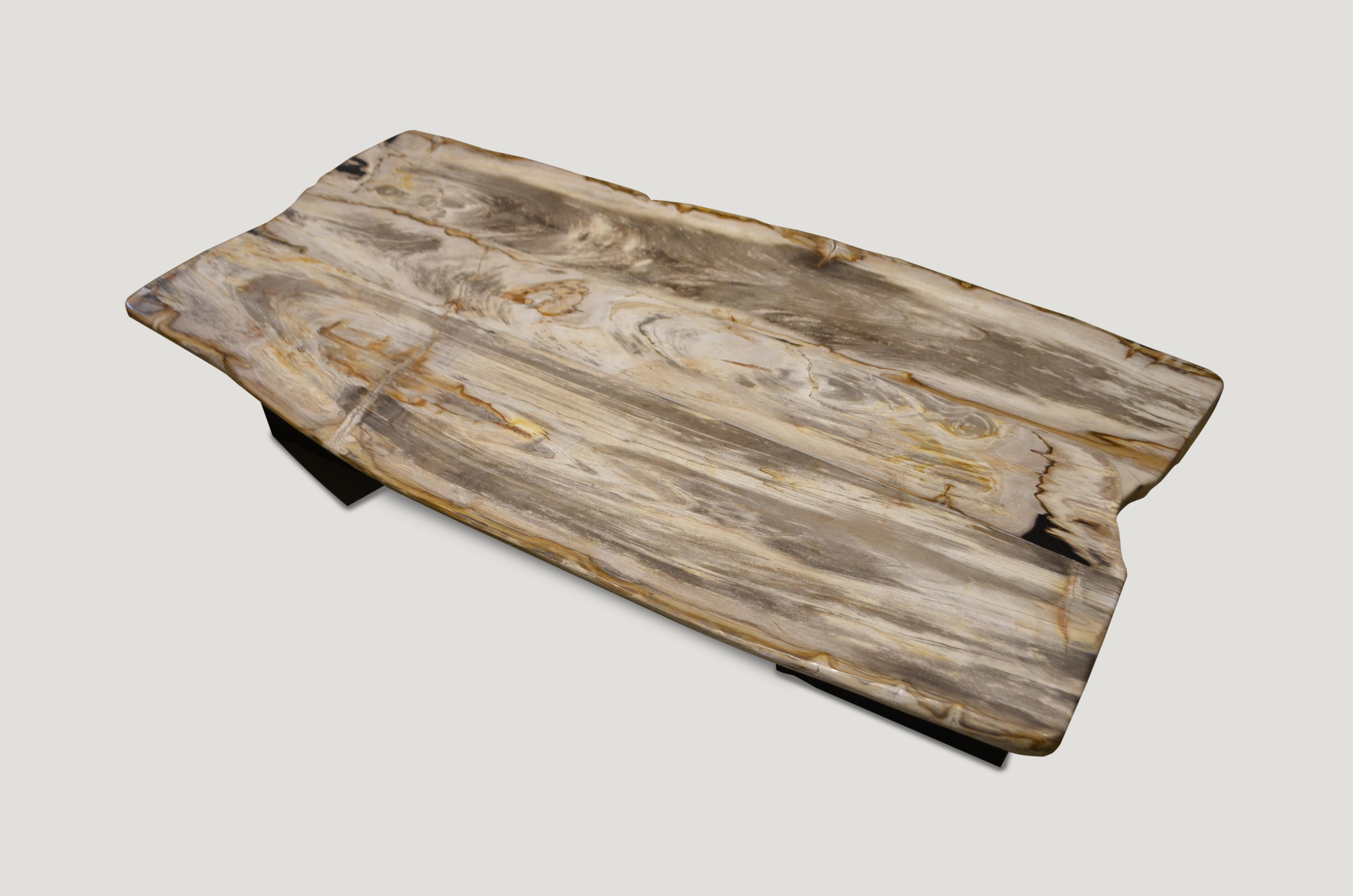 High quality super smooth petrified wood coffee table, dining table or counter top. Stunning creamy beige with contrasting black, charcoal grey and natural tones make this an impressive piece for any space. This two inch thick slab is shown floating