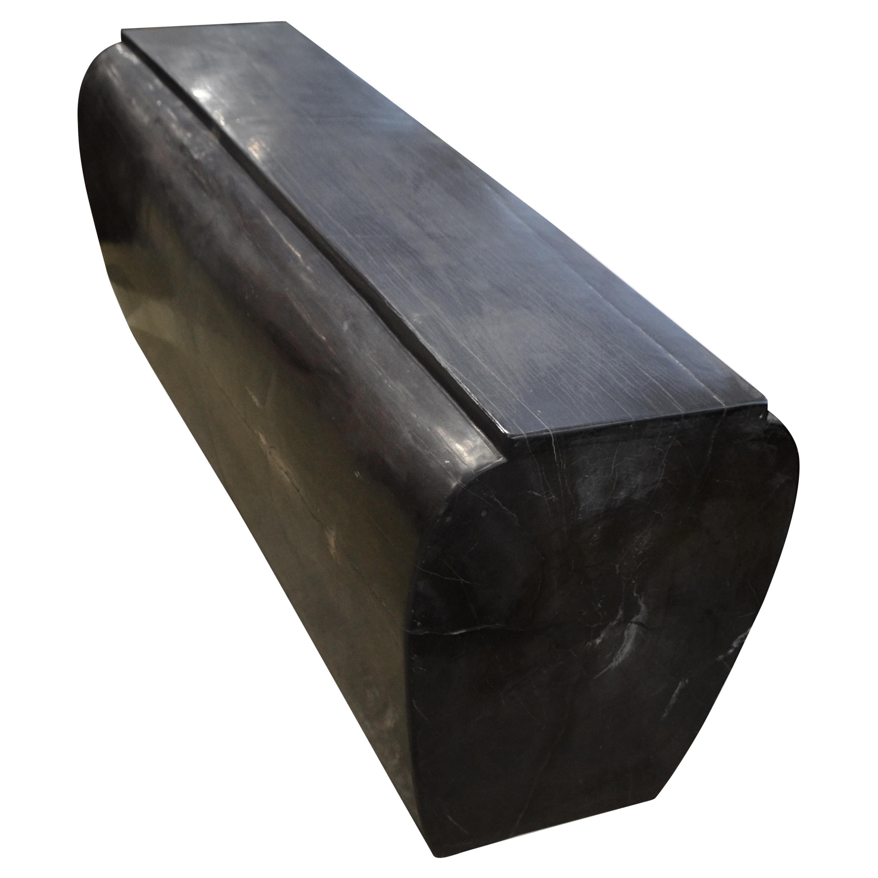 High quality super smooth petrified wood log bench. Stunning charcoal grey and black tones make this an impressive piece for any space. Beautifully shaped into a stunning sculptural bench with a bevelled top. To shape petrified wood with such