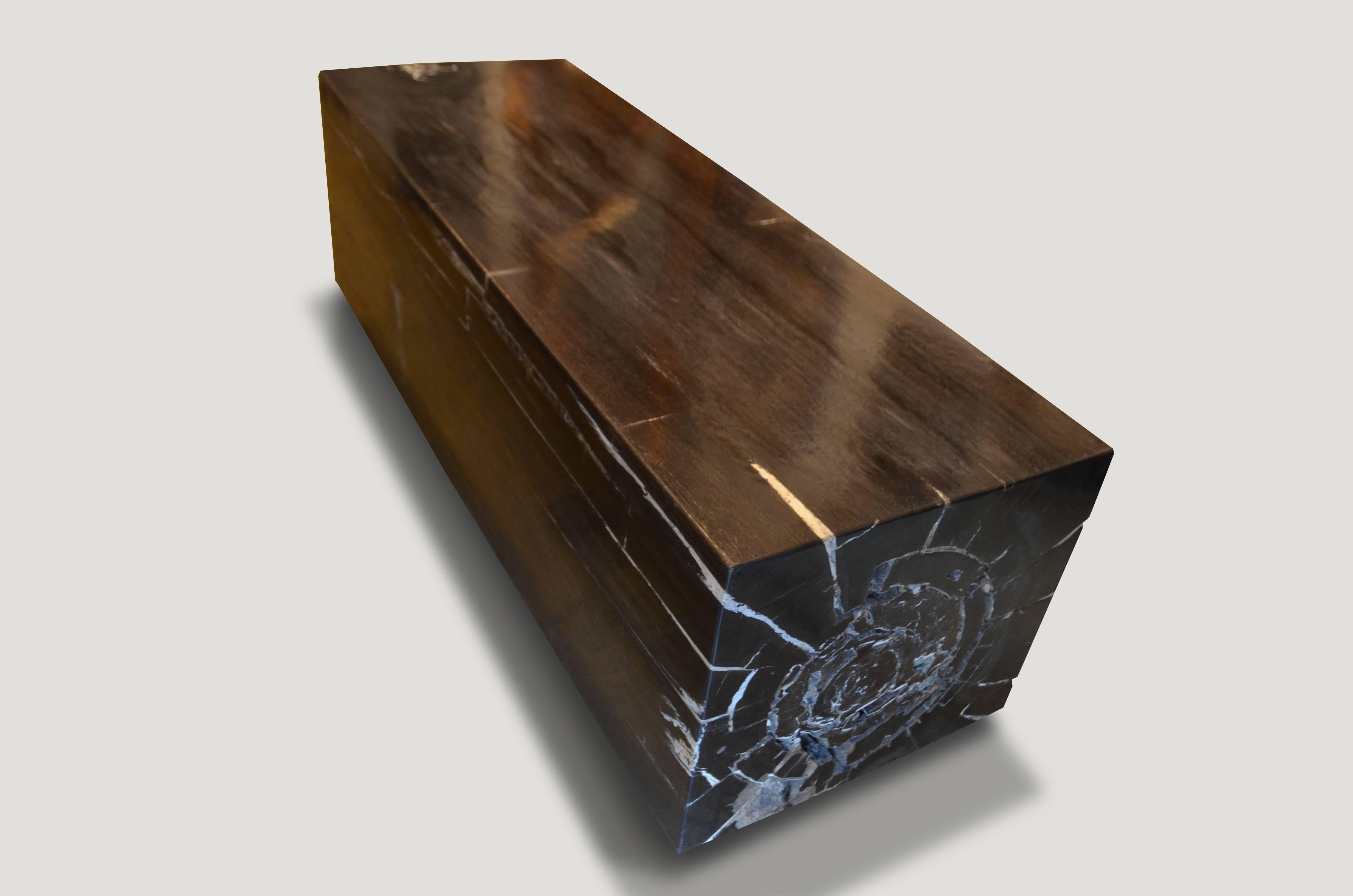 High quality super smooth petrified wood log bench. Stunning charcoal grey, black and white tones make this an impressive piece for any space. Floating on two espresso stained wooden bases which can be modified for a different height. Each side is