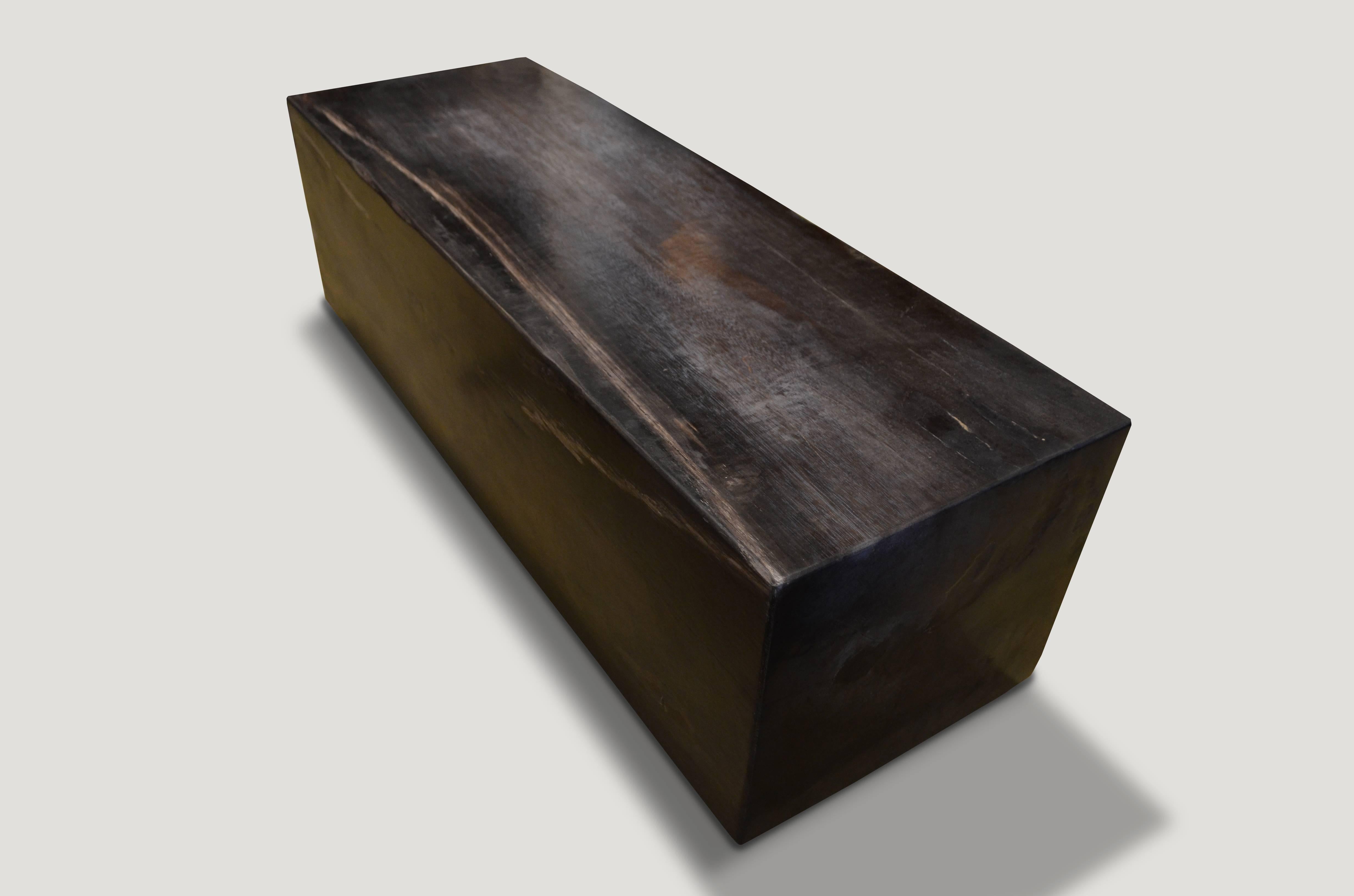 High quality super smooth petrified wood log bench. Stunning charcoal grey, black and white tones make this an impressive piece for any space. Floating on two espresso stained wooden bases which can be modified for a different height. Each side is