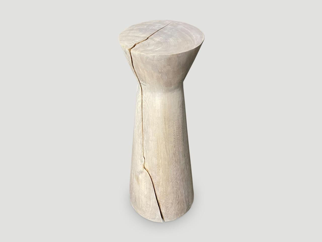 Beautiful hourglass tall side table made from solid suar wood. The bottom is 11” diameter and the top 9.5” diameter.

The St. Barts Collection features an exciting new line of organic white wash, bleached and natural weathered wood furniture. The