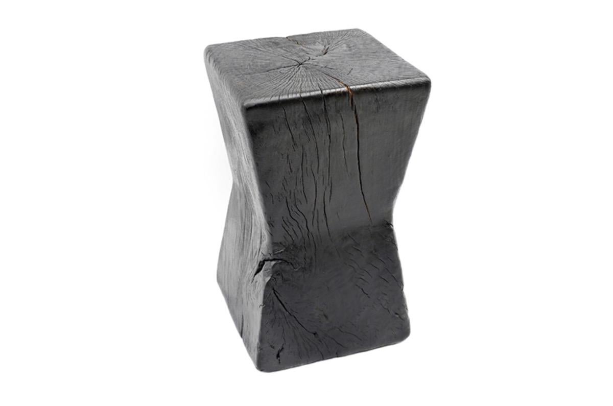 Solid hourglass shaped reclaimed tamarin wood side table. Burnt, sanded and sealed with a smooth finish.

The Triple Burnt collection represents a unique line of modern furniture made from solid organic wood. Burnt three times to produce a rich,