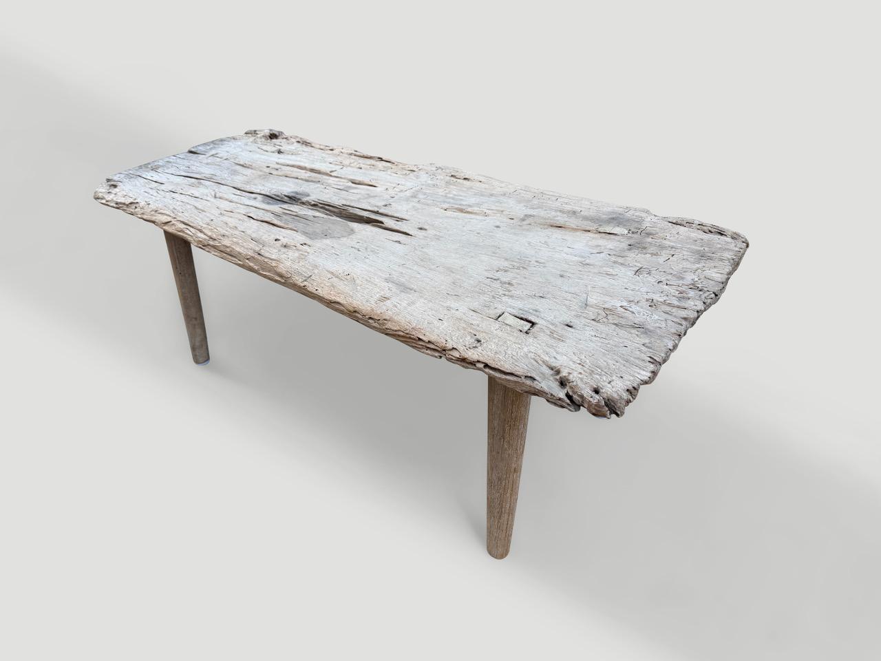 Un seul panneau de bois de teck récupéré avec un léger bord vif a été blanchi tout en respectant le bois organique naturel. Nous avons ajouté des papillons incrustés dans le plateau et des pieds minimalistes pour produire cette table basse unique en