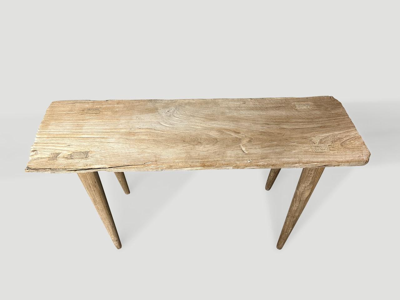 A single thick antique teak panel with lovely character within the wood. We added smooth teak minimalist legs and a butterfly inlay to produce this beautiful console table. Finished with a secret ingredient, revealing the unique wood grain. It’s all