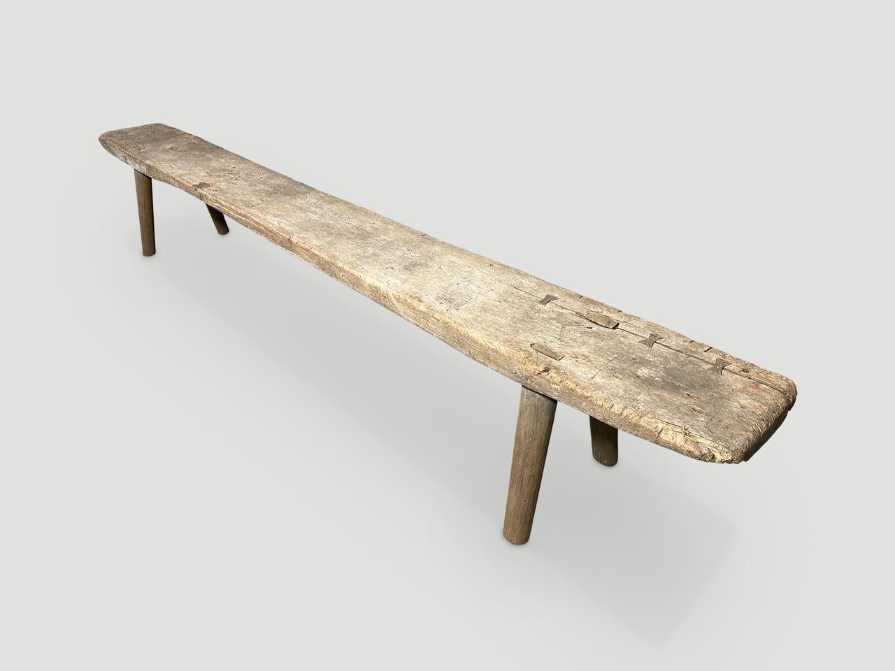 Antique Wabi Sabi teak wood bench celebrating the cracks and crevices and all the other marks that time and loving use have left behind. We added smooth teak minimalist legs to this two inch thick slab and butterflies inlaid into the top. It’s all