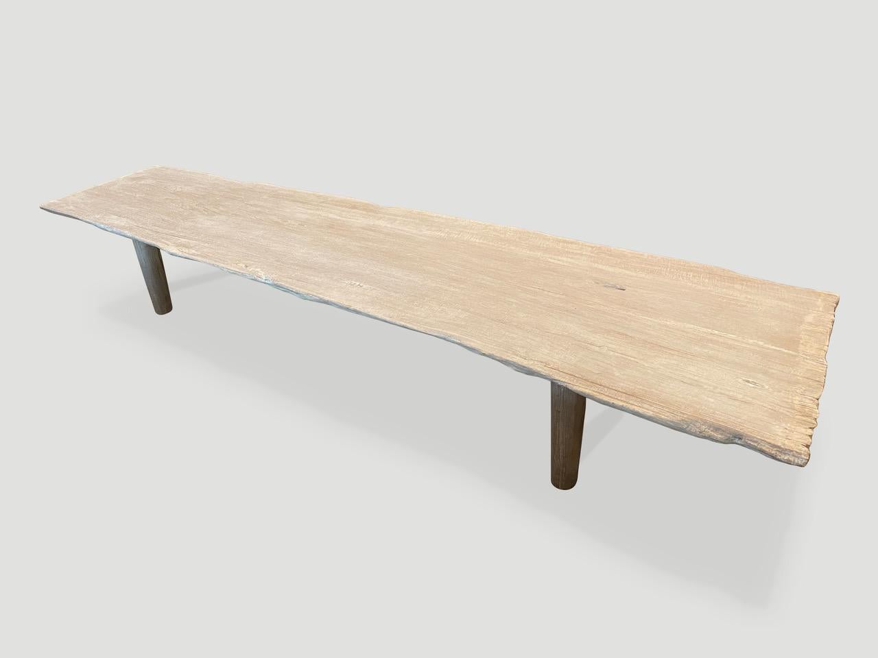 Impressive single slab, live edge bleached teak coffee table or bench with natural erosion on one end. We have added a light white wash finish revealing the beautiful grain on this reclaimed two inch teak slab. Finally we added minimalist legs.