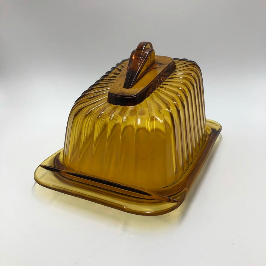 Amber pressed glass cheese dome with matching underplate, designed in 1939 by the famous Dutch designer Andries Copier for Leerdam glass factory. The dome is part of the H-collection (Household), a multi-functional design collection. The liqueur