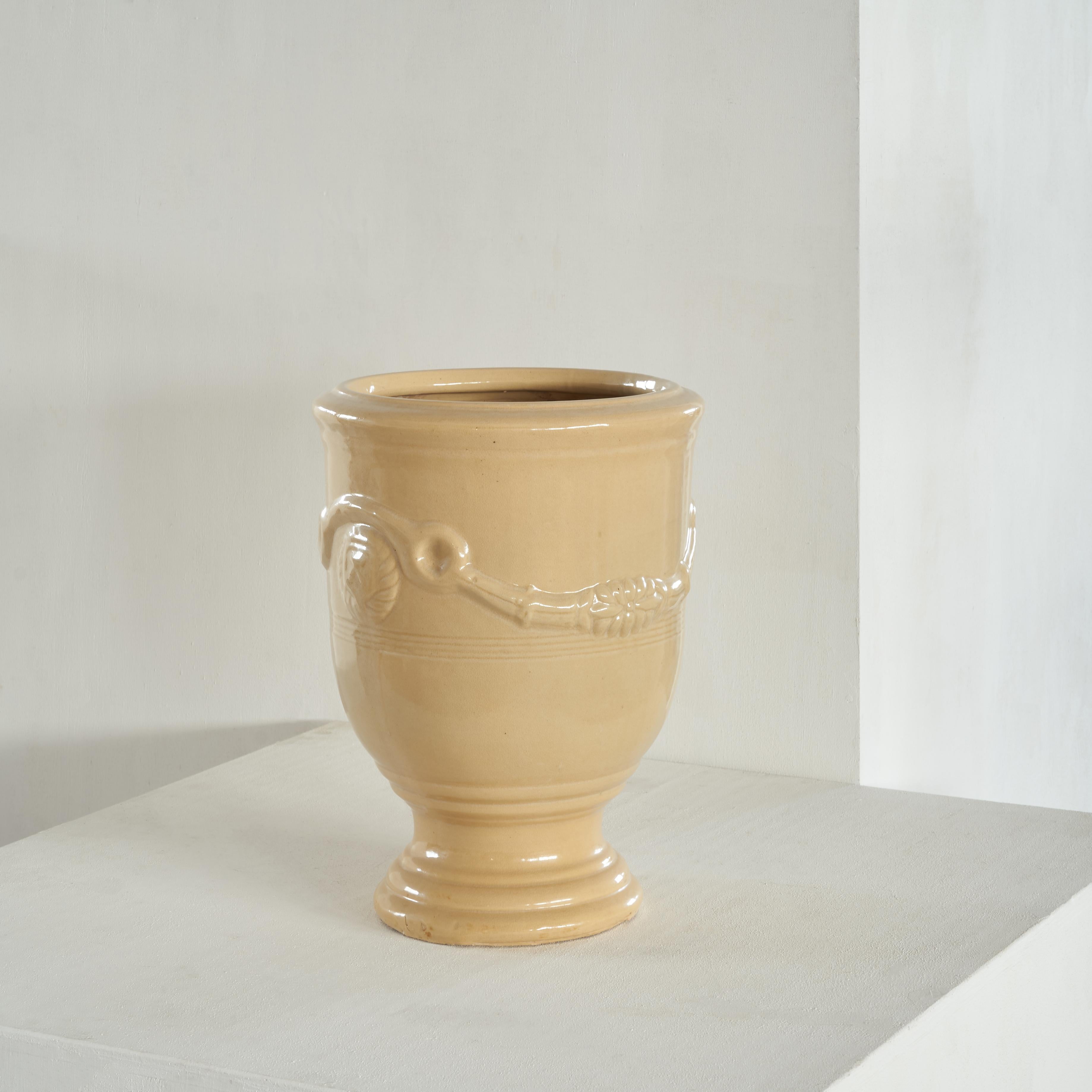 Anduze Pot in Cream Yellow, France, Mid 20th century.

This well sized Anduze pot has a warm cream yellow color and a glazed surface, showing a rich high gloss. The proportions of this original piece are well chosen, it has a firm yet elegant