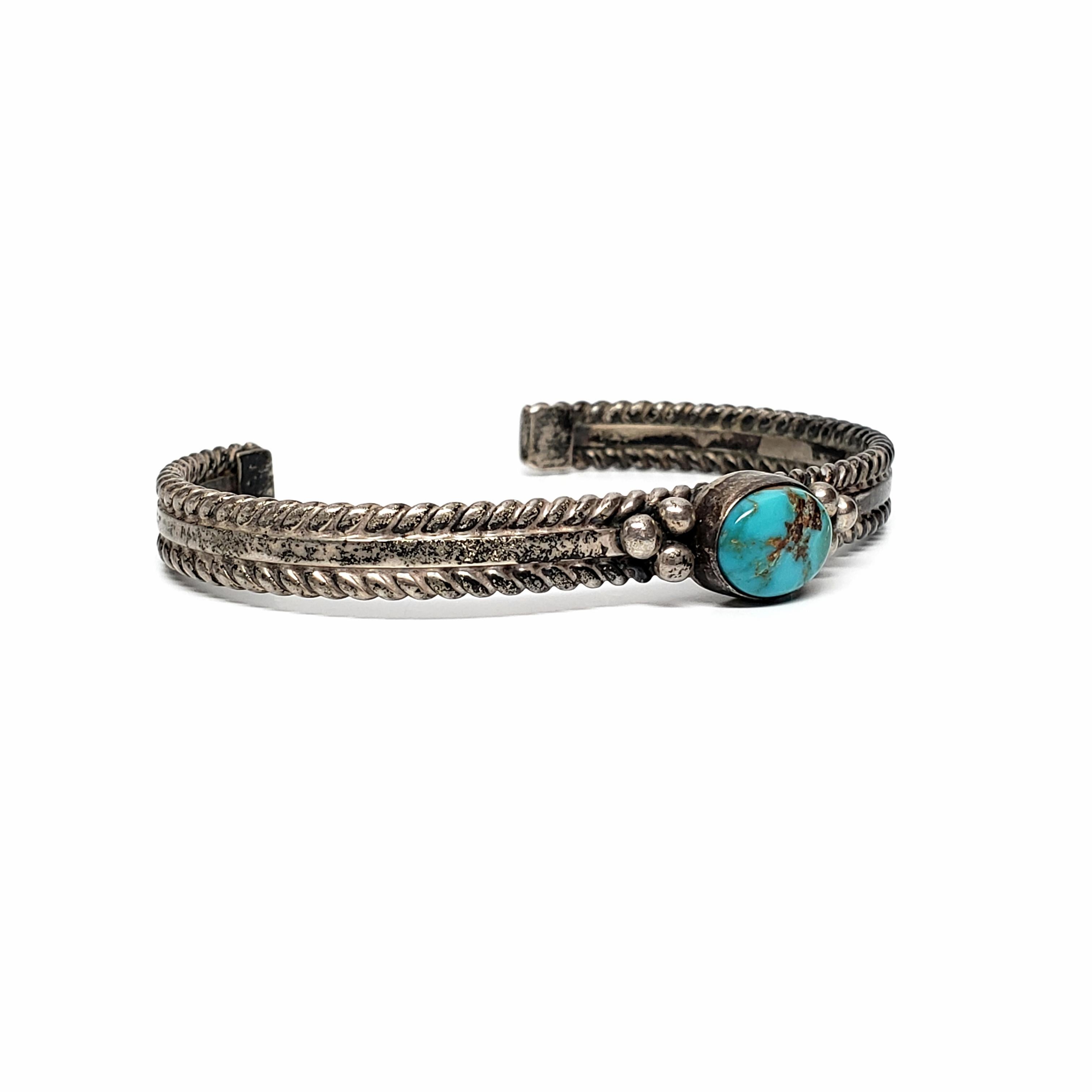 Sterling silver and turquoise cuff bracelet by Native American artisan, Andy Cadman.

Andy Cadman has been making handmade jewelry for 25+ years. Bezel set oval turquoise adorned with silver beaded accents and rope edging.

Measures approx 5 1/4