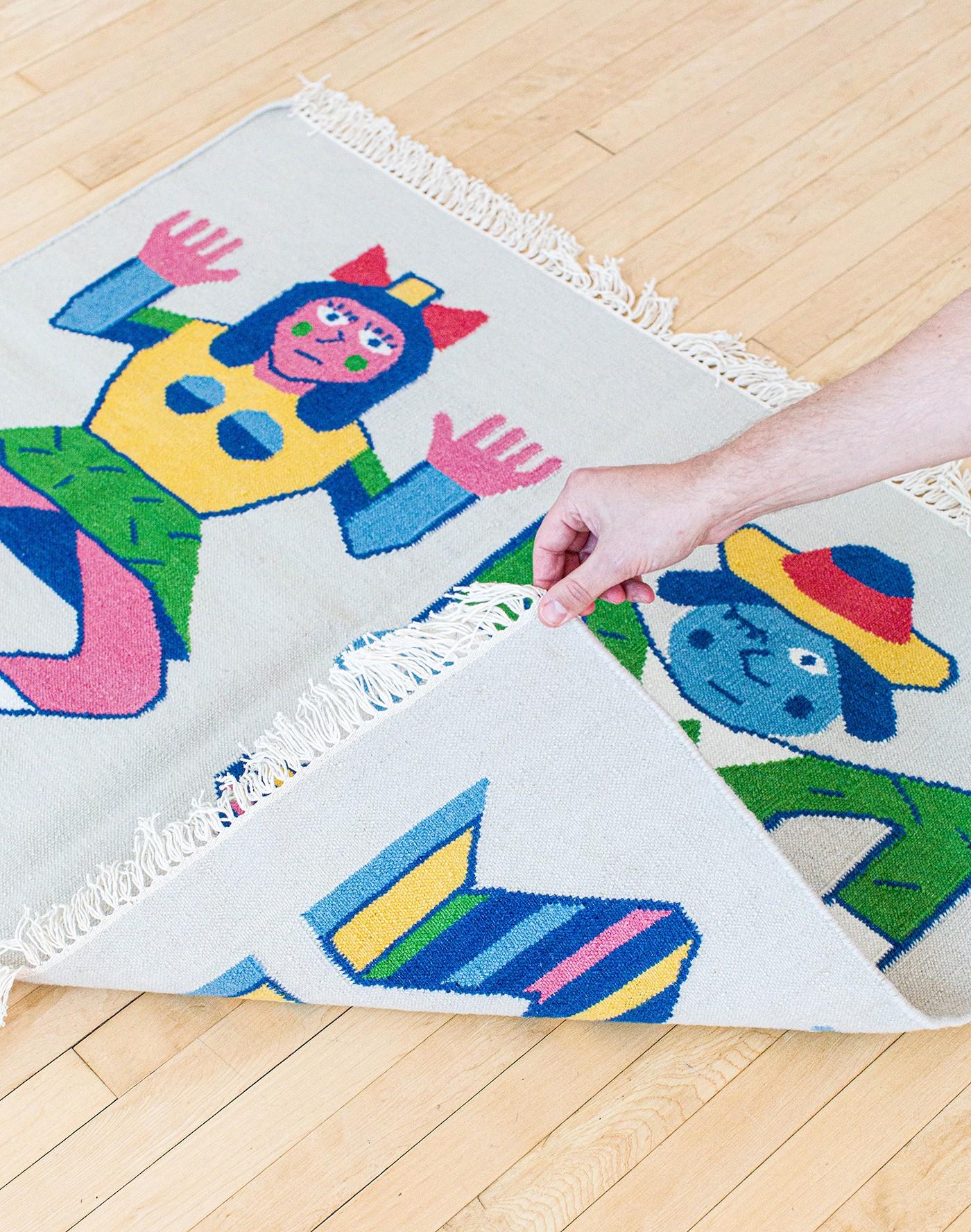 Together Apart is a collaboration between artist Andy Rementer (USA) and Case Studyo (Belgium). This colorful and playful handwoven kilim rug is produced in an edition of 50. The rug shows a couple that at first glance appear to be dancing. The