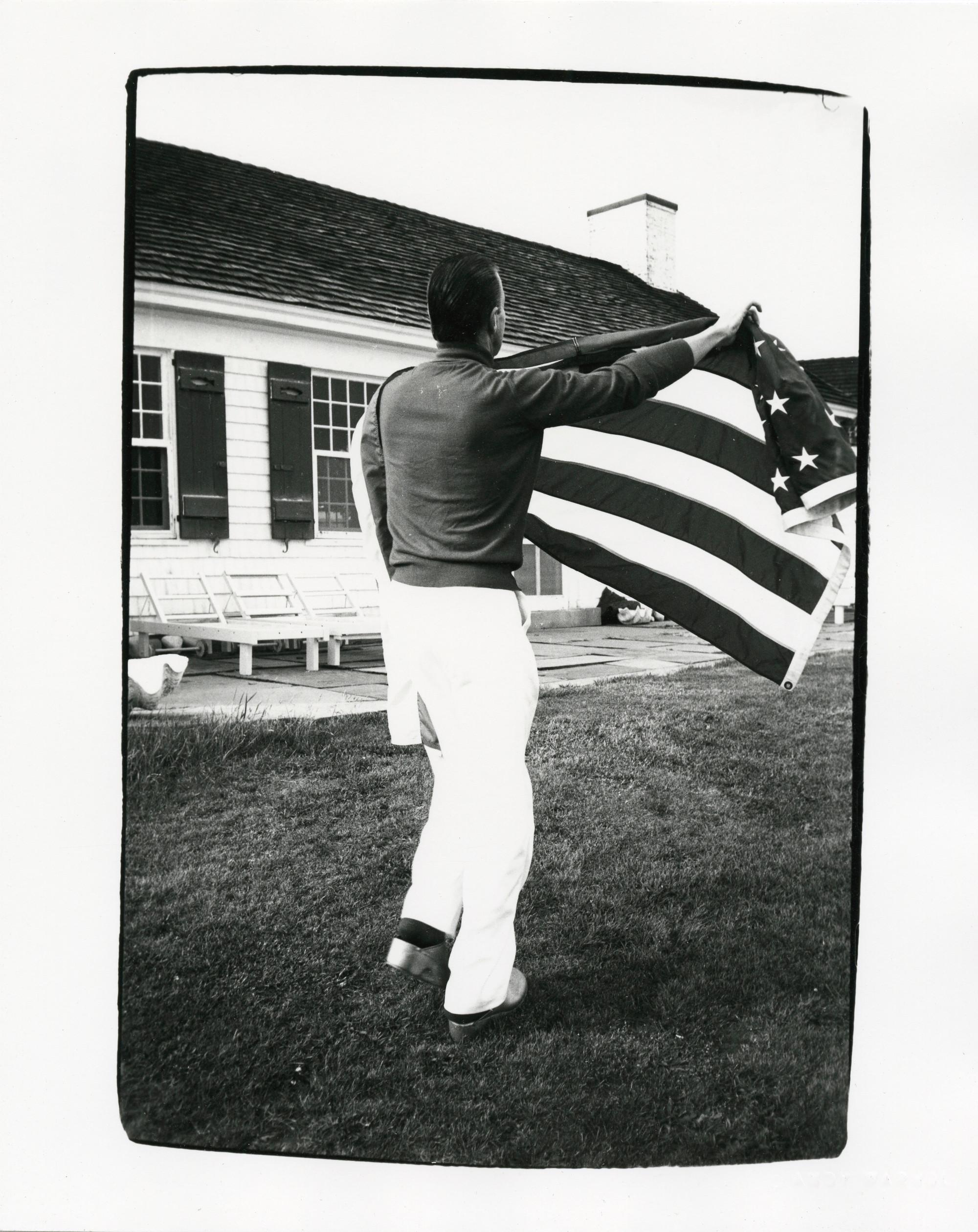 Andy Warhol Portrait Photograph – Halston hält die amerikanische Flagge im Nachlass von Warhol in Montauk
