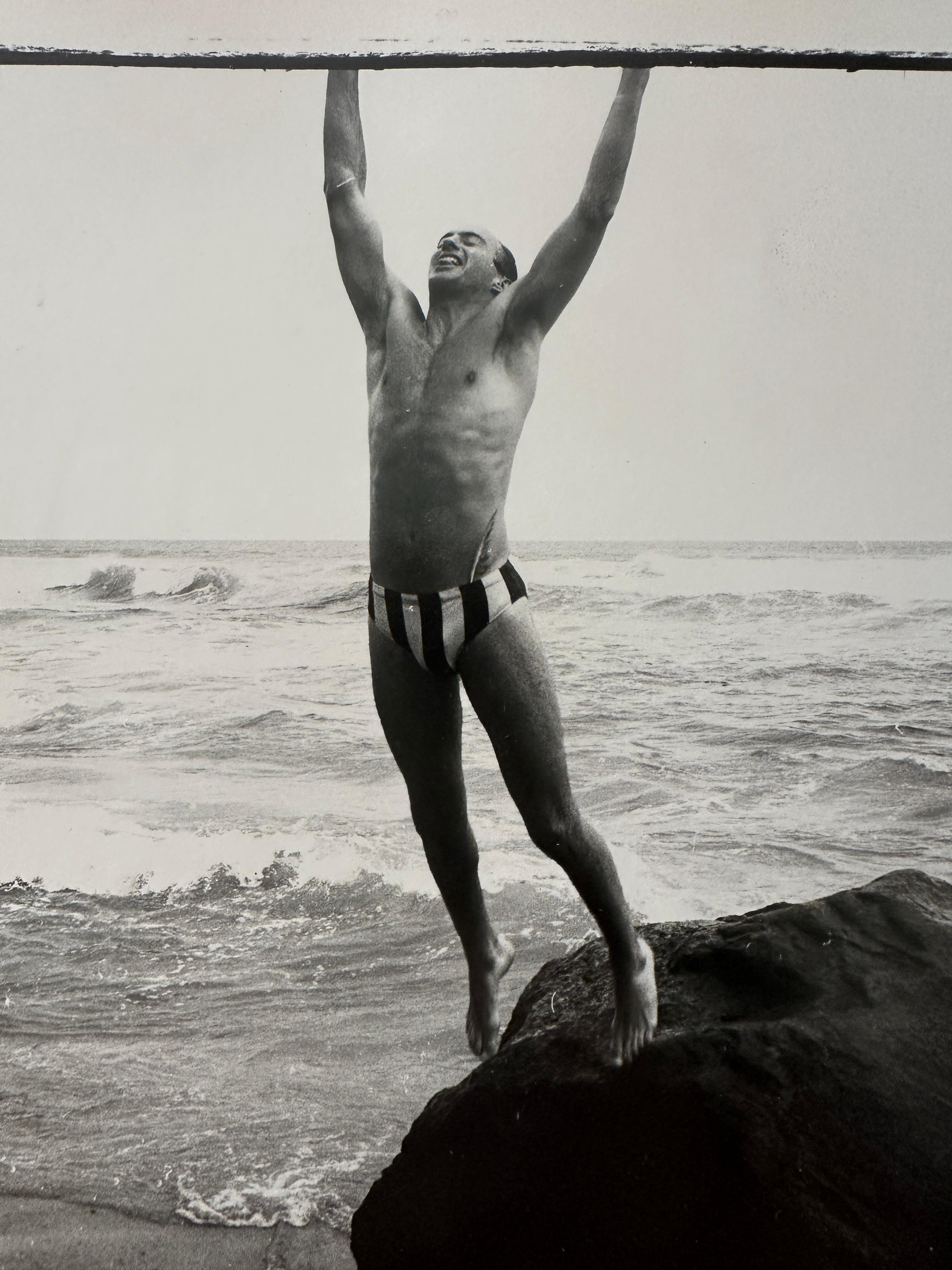 Jon Gould sautant du rock à Montauk - Beige Black and White Photograph par Andy Warhol
