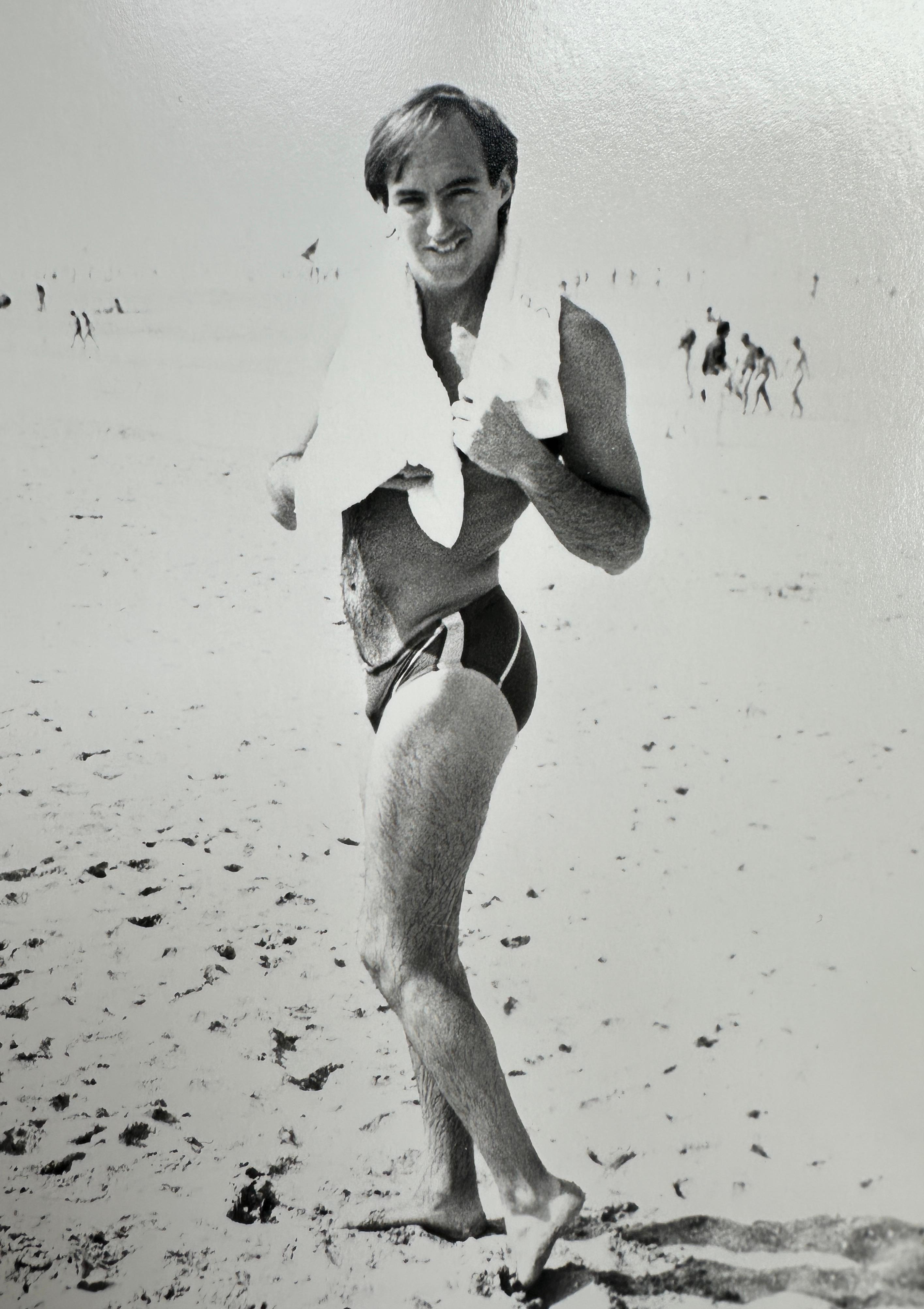 Jon Gould am Strand mit Handtuch in Deauville, Frankreich (Grau), Figurative Photograph, von Andy Warhol