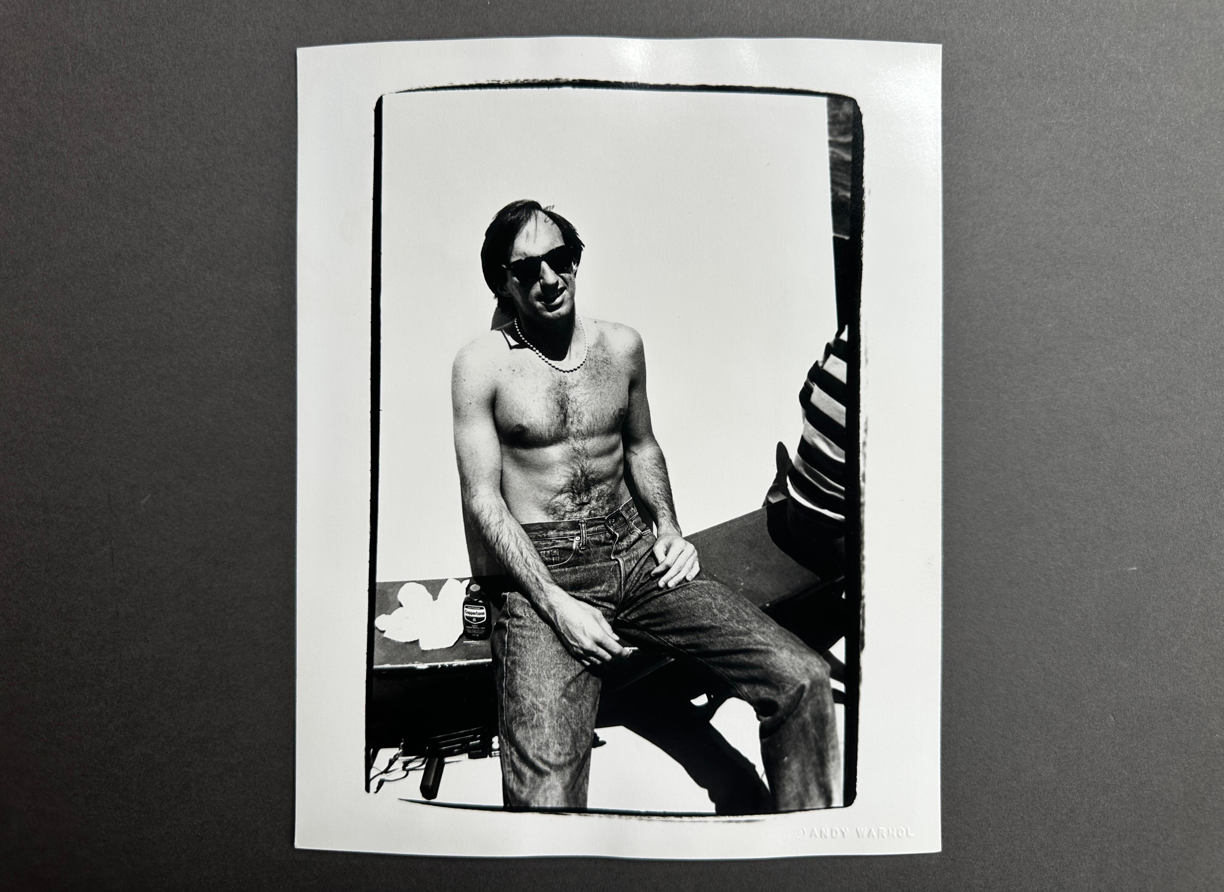 Jon Gould Sunbathing Shirtless with Jeans Seated in Cape Cod - Pop Art Photograph by Andy Warhol