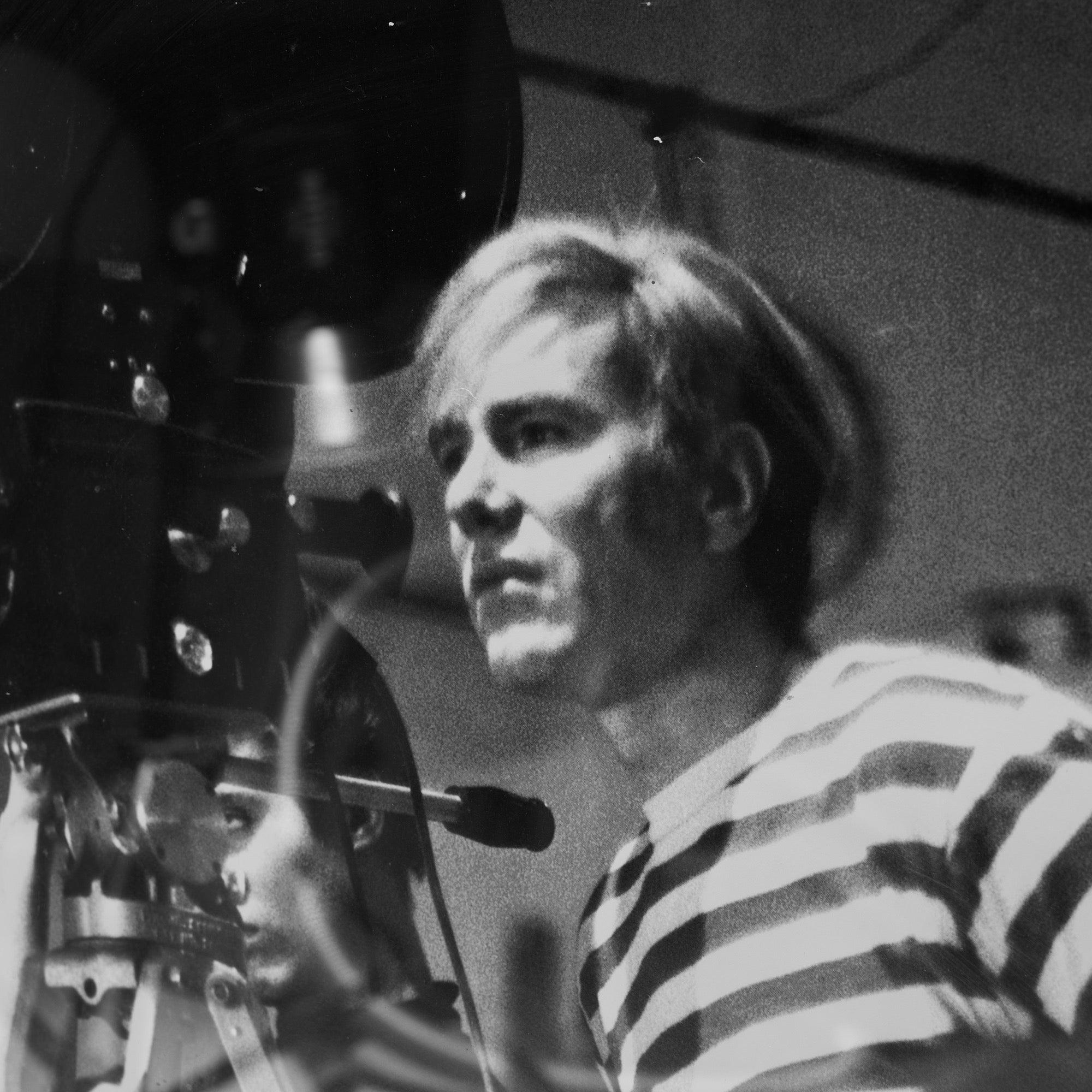 Poster of Andy Warhol in front of camera.