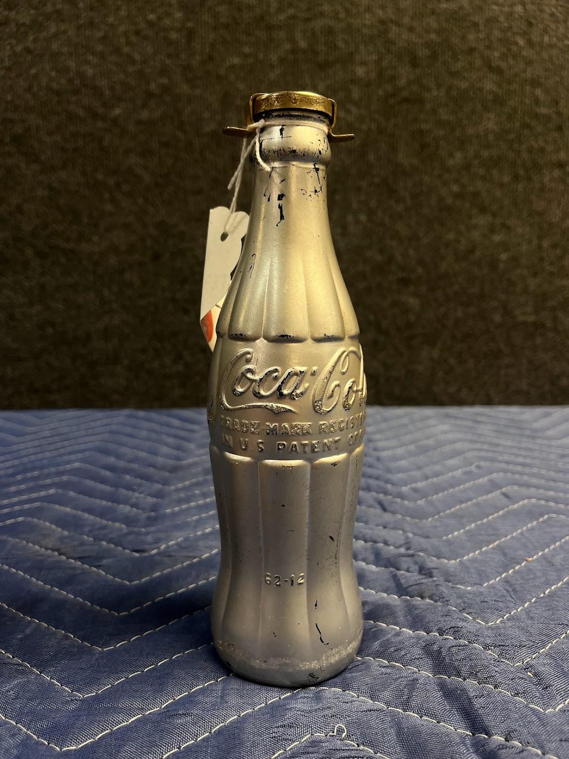 ANDY WARHOL (1928-1987)

Coca-Cola glass bottle, metal bottle stopper and spray paint. Signed with initials by the artist in black ink ‘A. W.’ Executed in 1967.