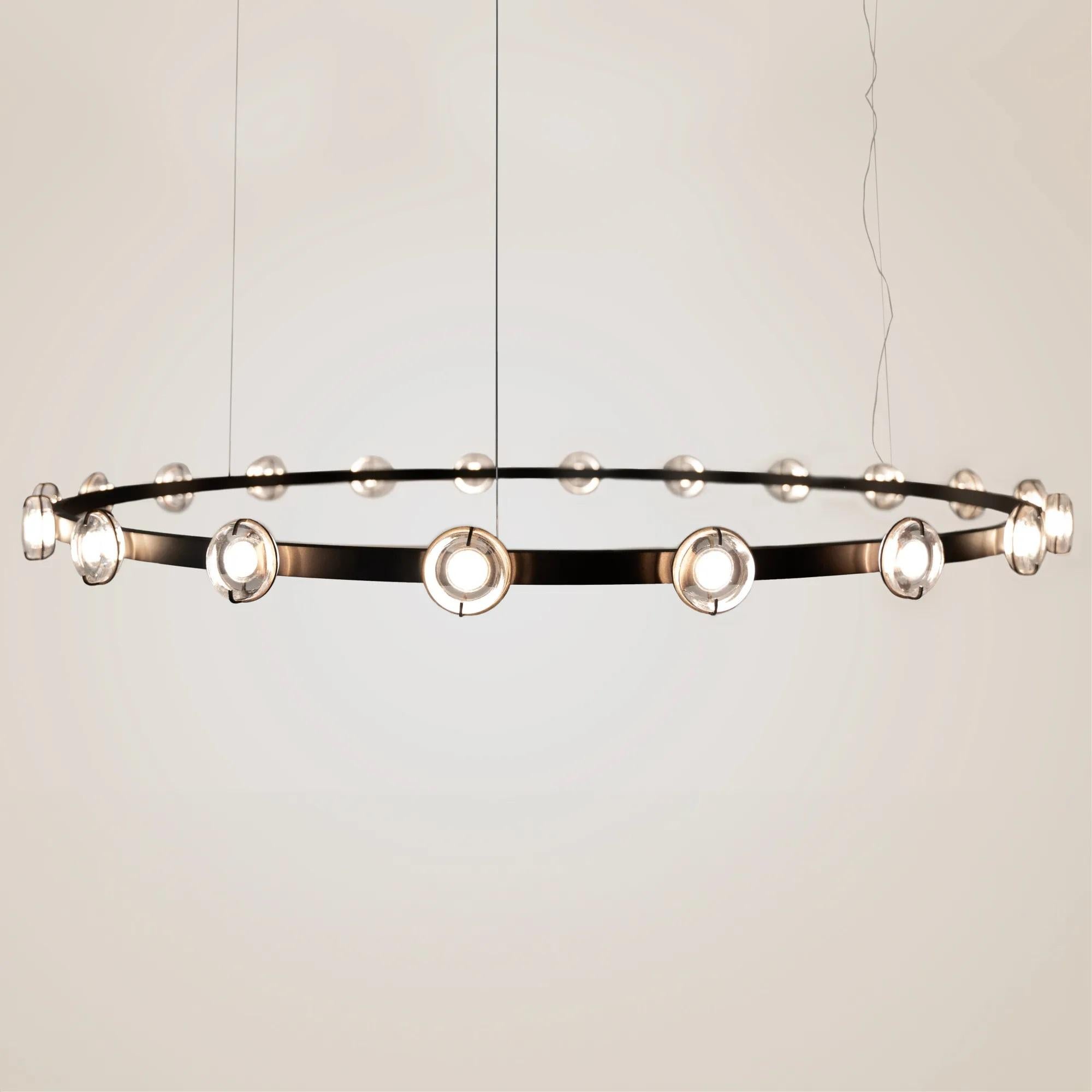 Lampada a sospensione Anel 80 di WJ Luminaire
Dimensioni: Ø 80 x H. 500 cm. 
Materiali: Alluminio e cristallo. 

Disponibile in diverse opzioni di colore del metallo e del vetro. La lunghezza del filo è di 500 cm. Disponibile in due diverse
